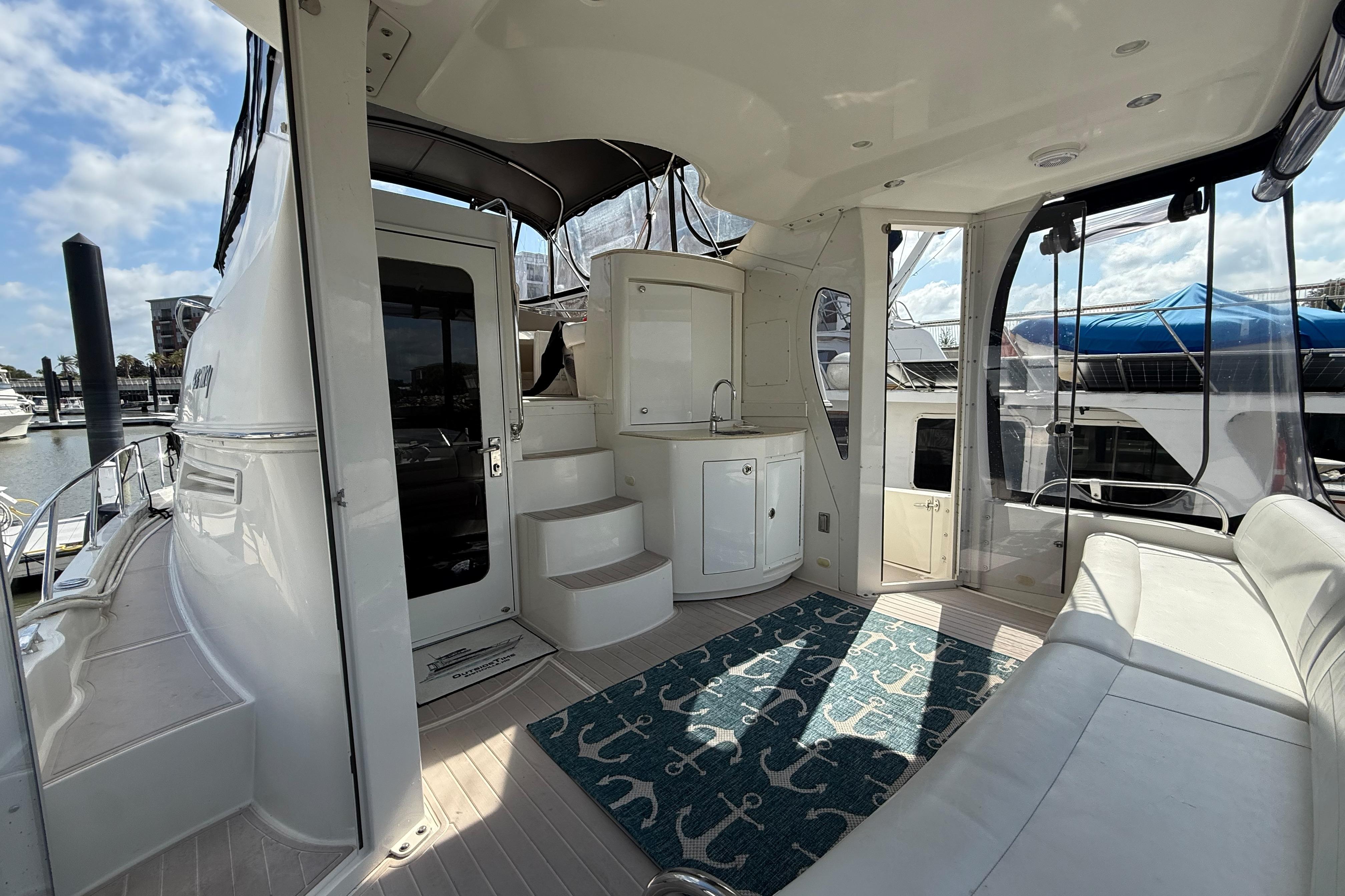 2006 Carver 43 Motor Yacht interior with seating, kitchenette, and nautical-themed rug.
