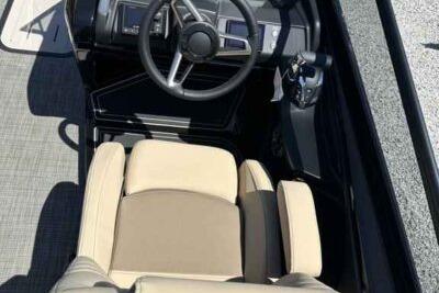 2025 SunCatcher Amara boat interior with steering wheel and beige seating.