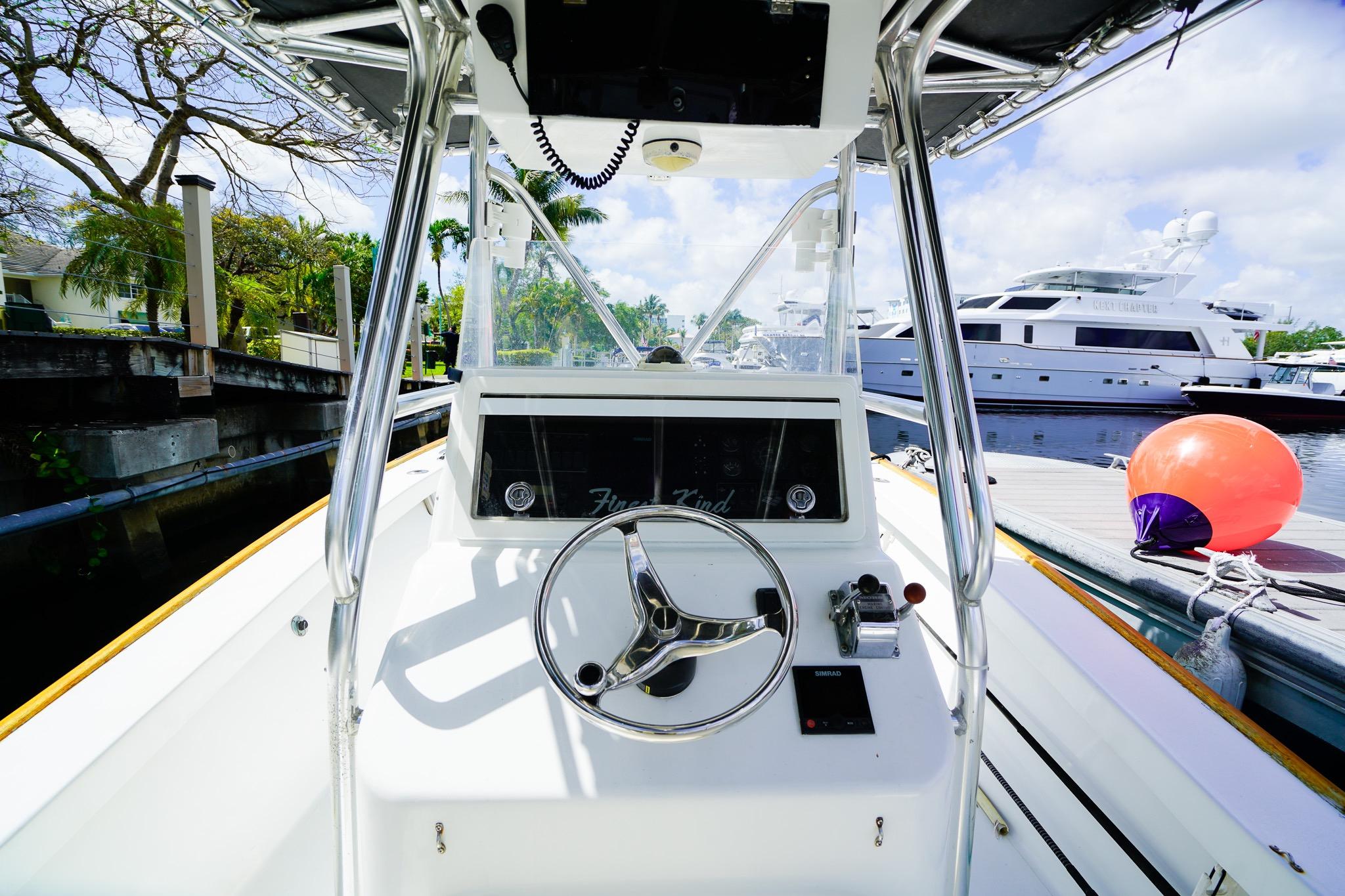 1977 Scarborough 27 CC boat helm with steering wheel, docked near yachts.