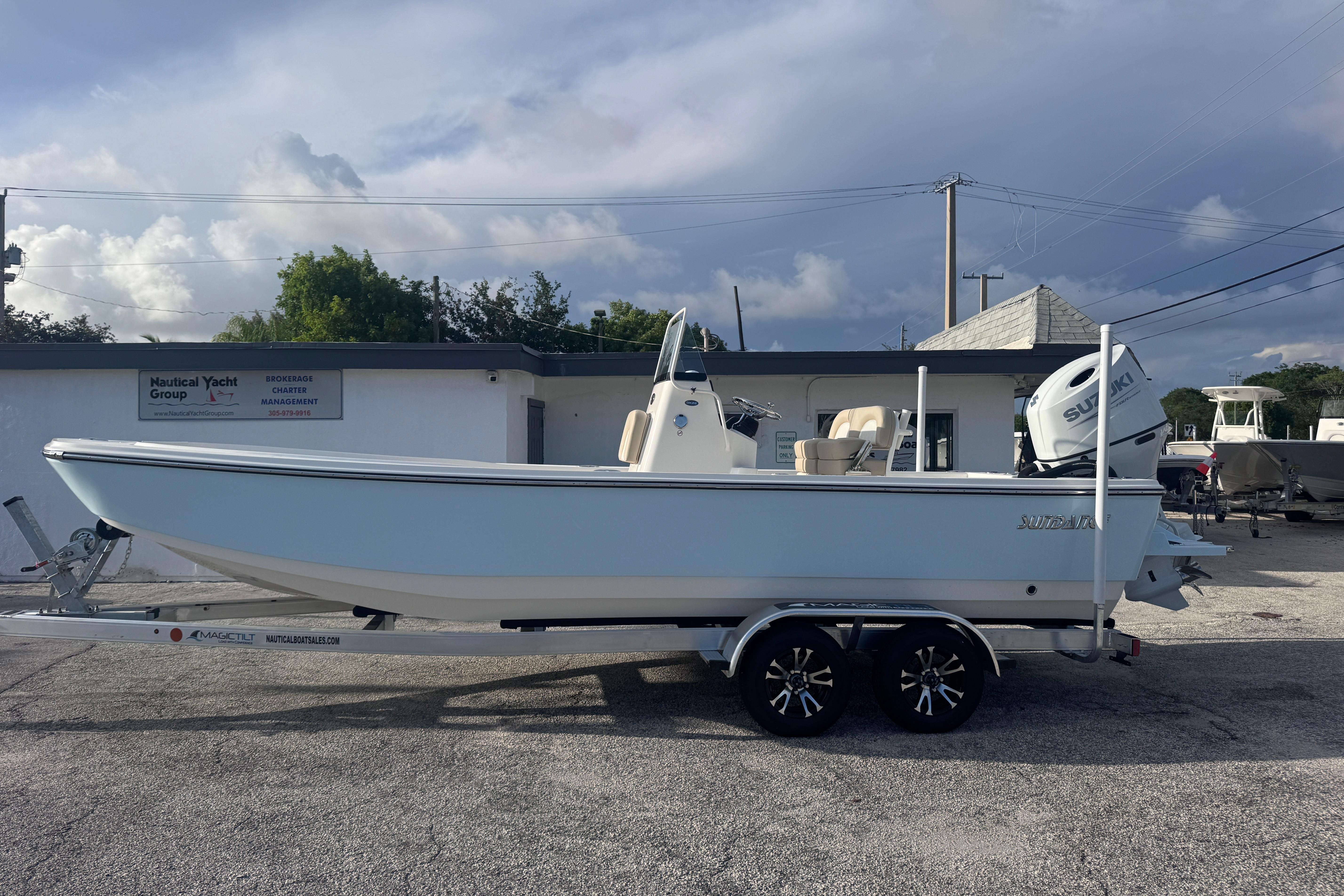 2026 Sundance DX22 boat on trailer, parked outside Nautical Yacht Group building.