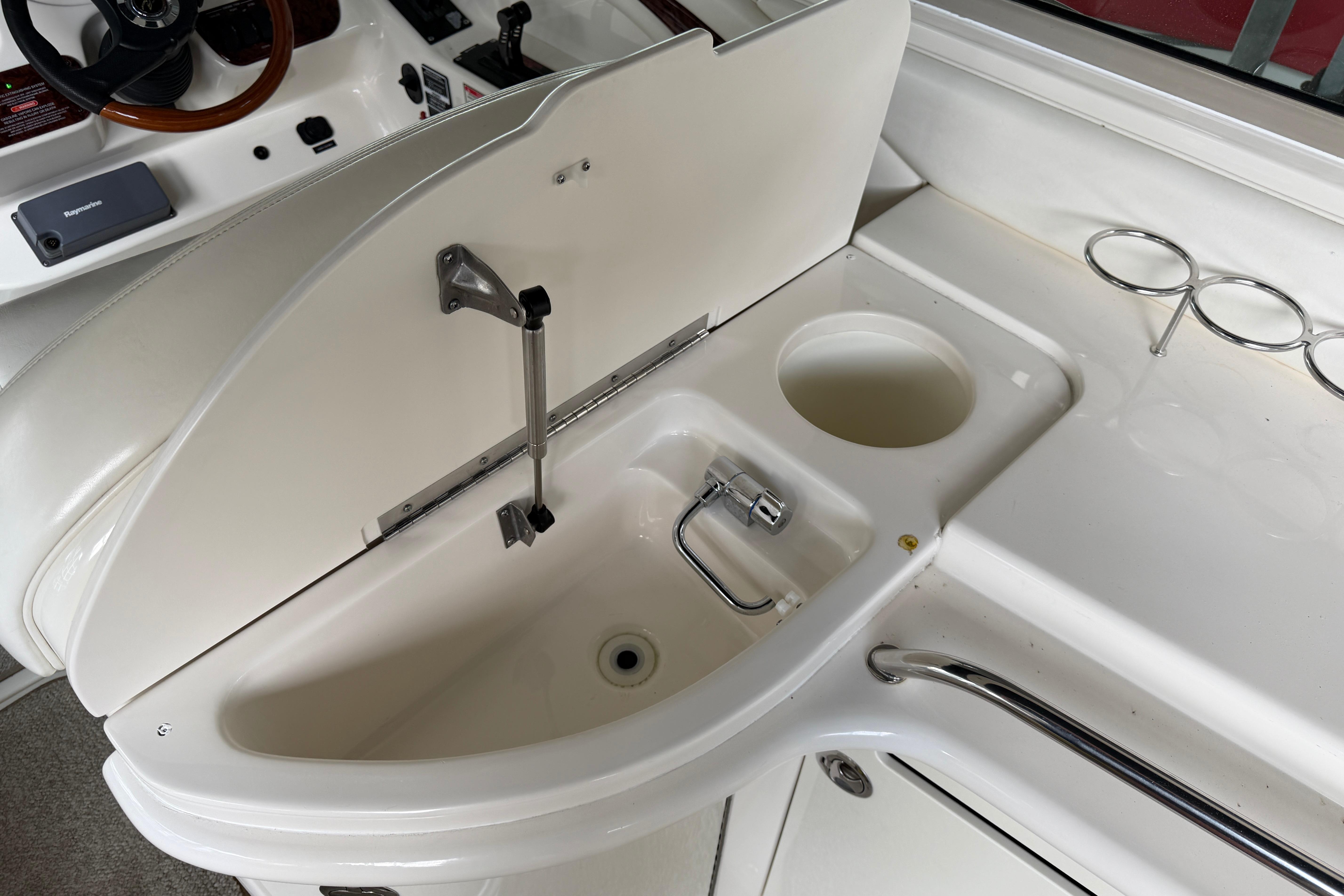2003 Sea Ray 290 Bowrider boat interior with sink and cup holders.