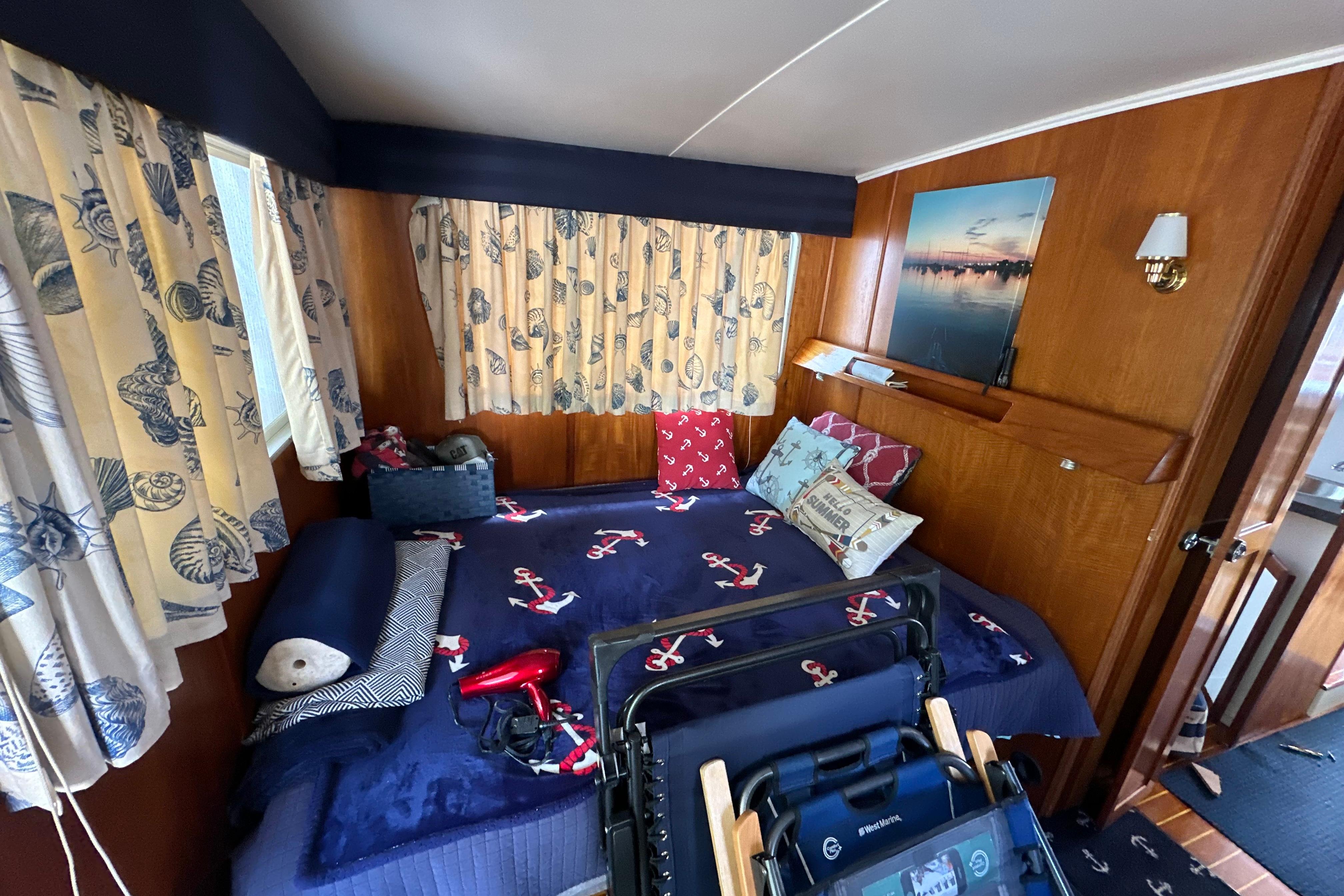 Cozy cabin interior of 1985 Pearson 43 Trawler with nautical-themed decor and wooden paneling.
