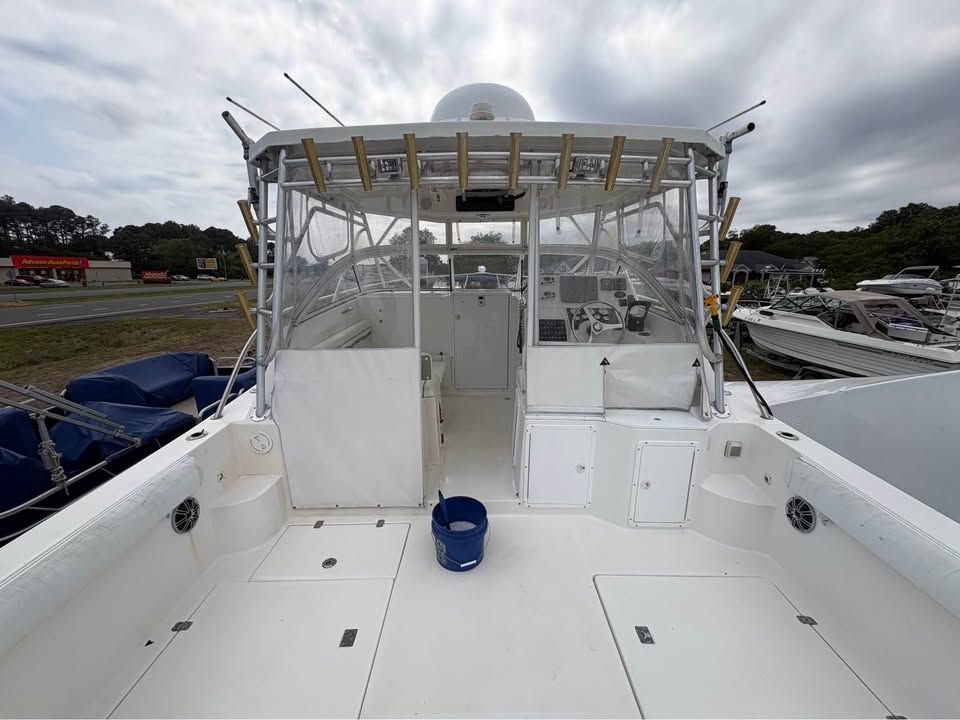 The image shows the spacious deck of a 2006 ProKat Pro Sport 3660 boat with fishing rod holders.