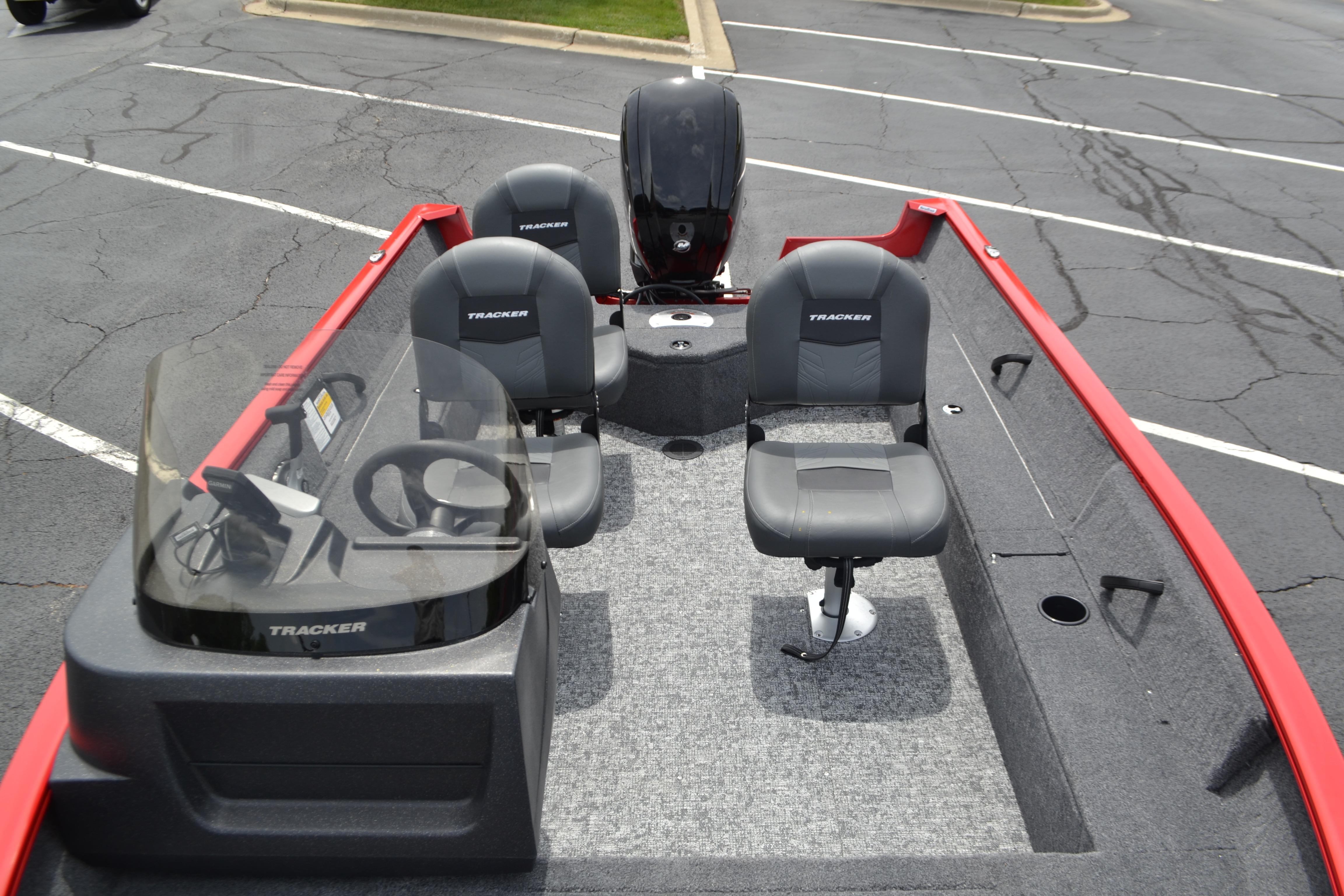 2026 Tracker Pro Guide V-16 SC boat with seating and steering console in a parking lot.