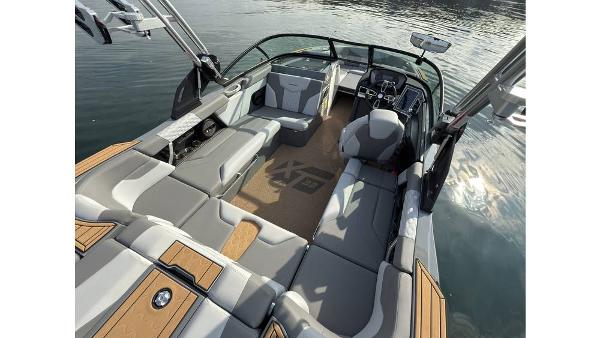 2023 MasterCraft XT22 boat interior with spacious seating and modern dashboard on calm water.