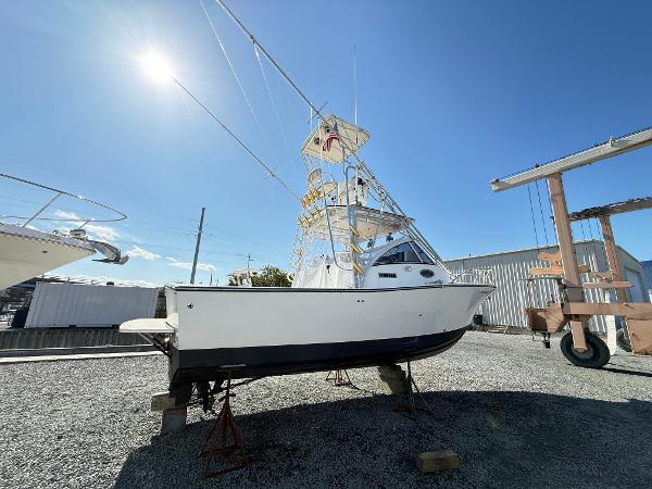2001 Albemarle 280 Express Sport Fisherman boat on dry dock under clear blue sky.