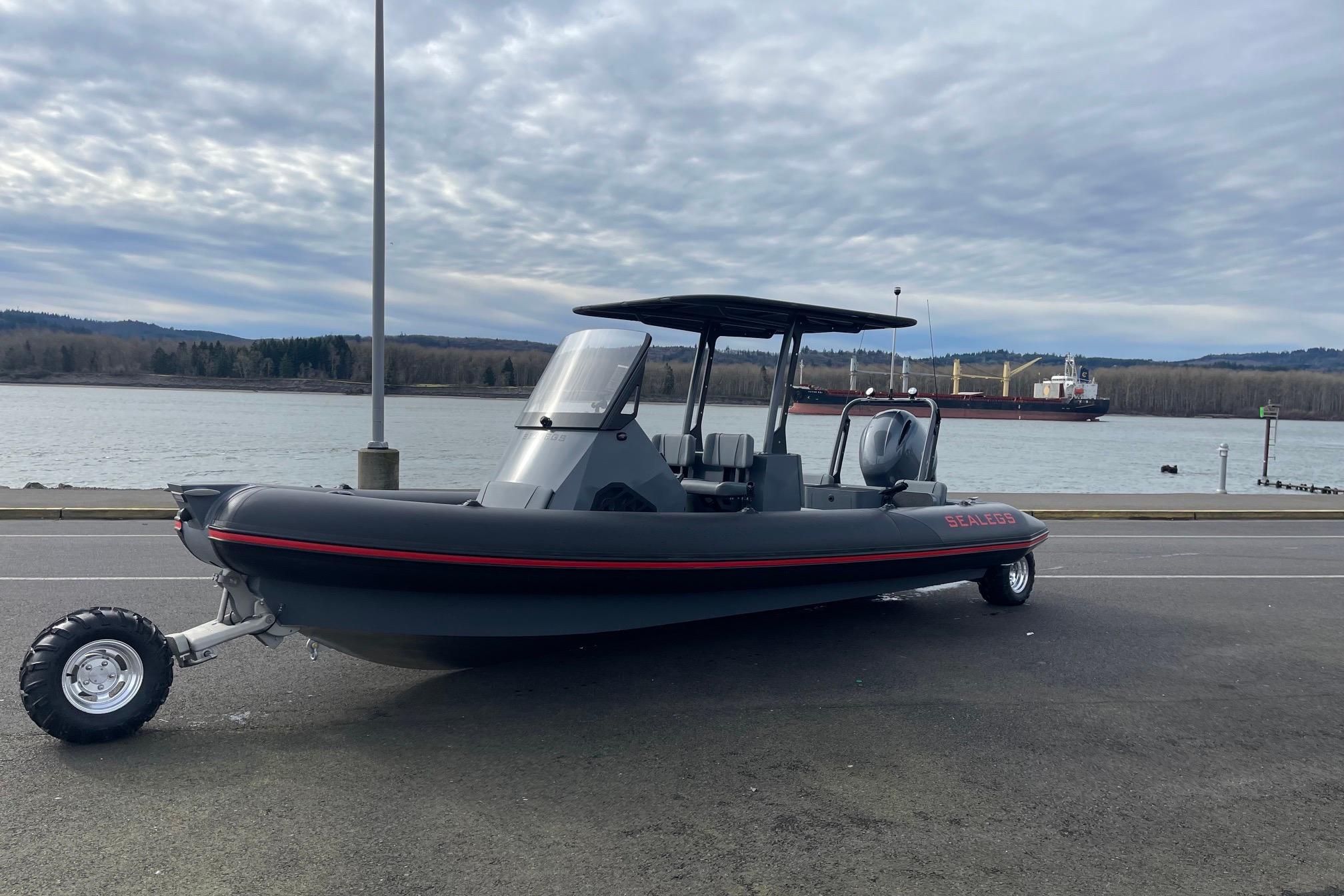 2024 Sealegs 7.5 amphibious boat parked by a riverside under cloudy skies.