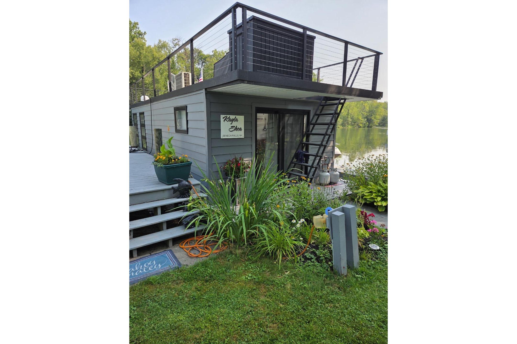 Houseboat "Freedom 40" by East Coast Houseboats, 2021, docked with rooftop deck and garden.