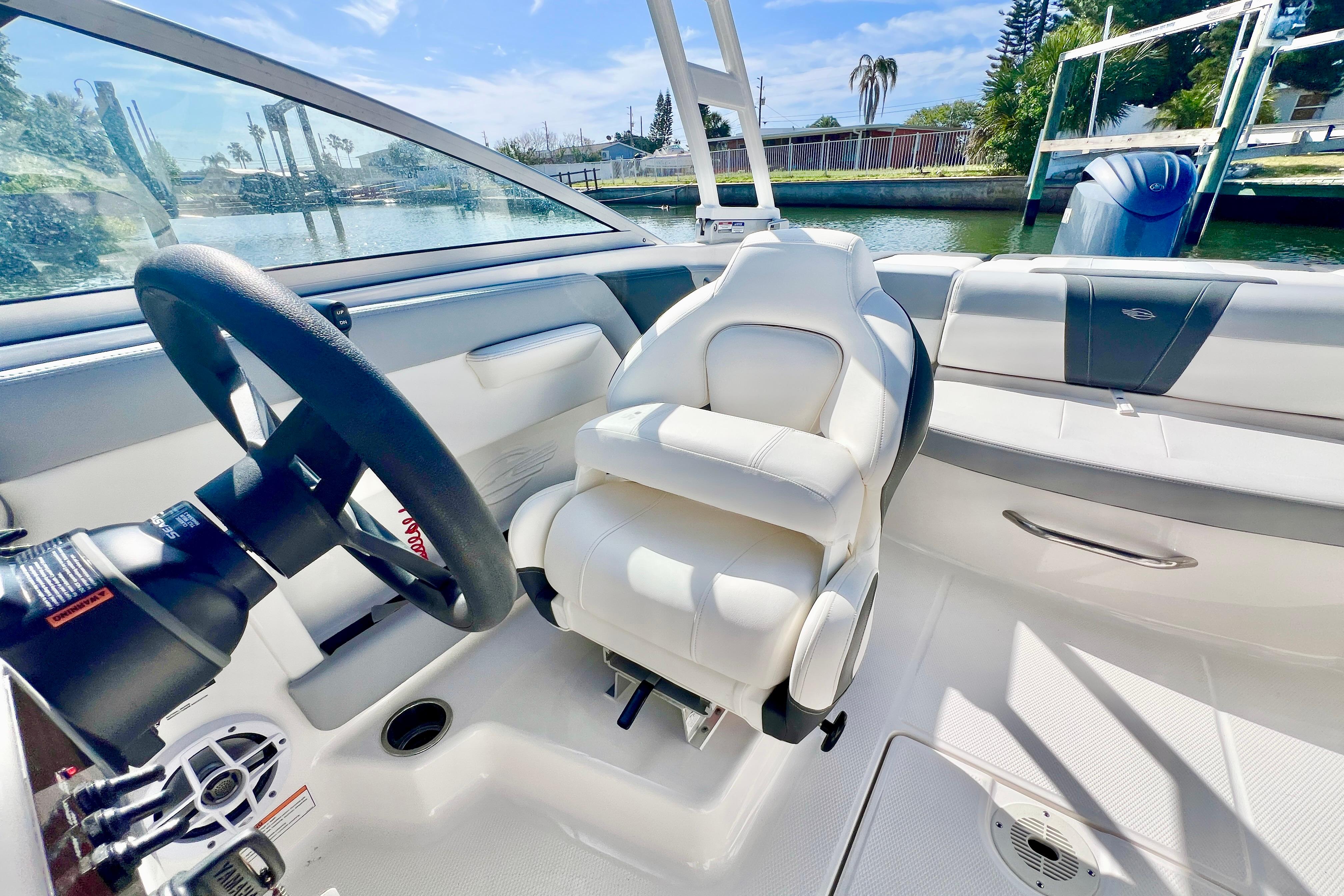 Interior of 2023 Chaparral 21 SSi OB boat with white seating and steering wheel.