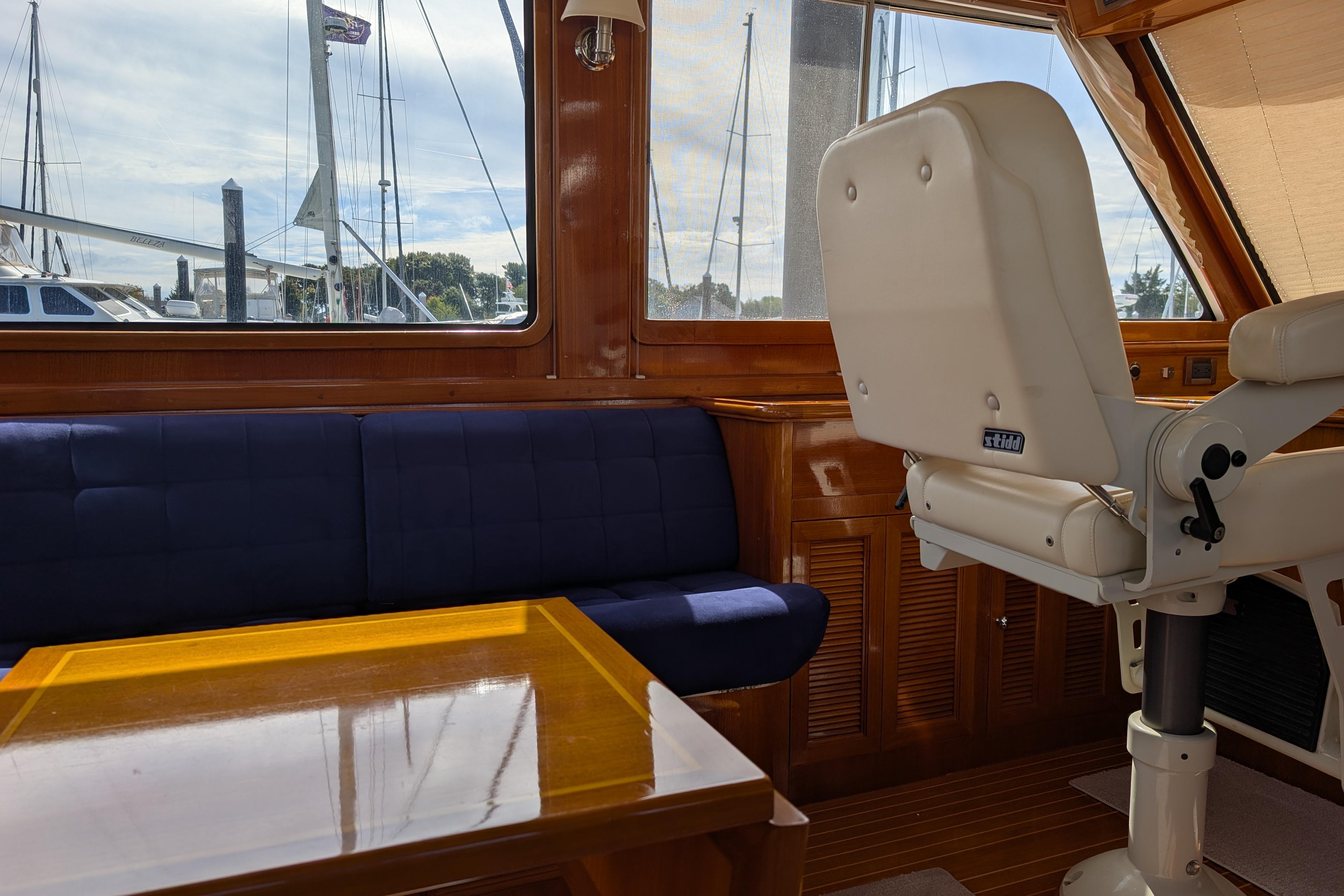 Interior of 2006 Grand Banks 49 Eastbay SX yacht with blue seating and wooden table.