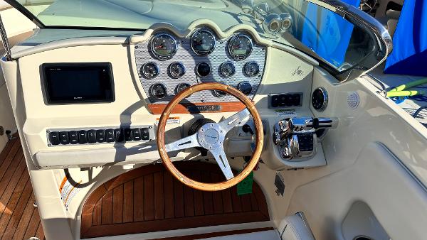 2014 Chris-Craft 28 LAUNCH boat dashboard with wooden steering wheel and modern controls.