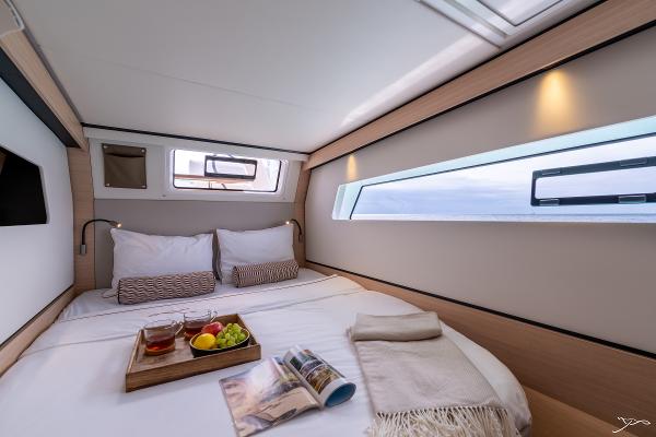 Luxurious cabin interior of 2025 Nautitech 44 Open with cozy bed and breakfast tray.