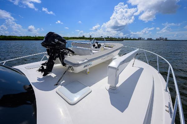 2000 Viking 50 Convertible yacht with a small boat on deck, under a clear blue sky.