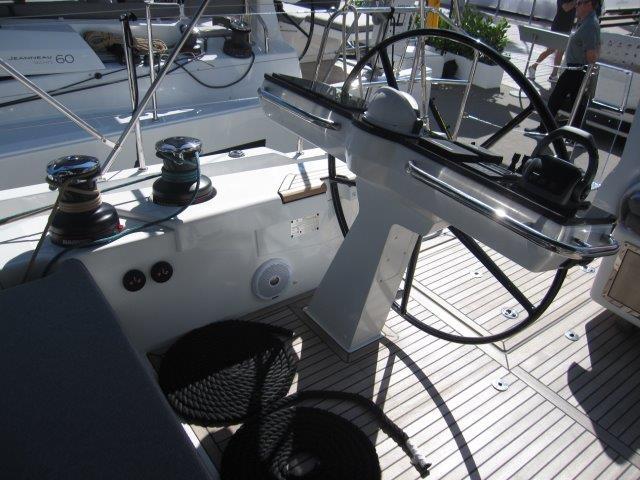 Cockpit of 2025 Jeanneau Yacht 65 with steering wheel and winches.
