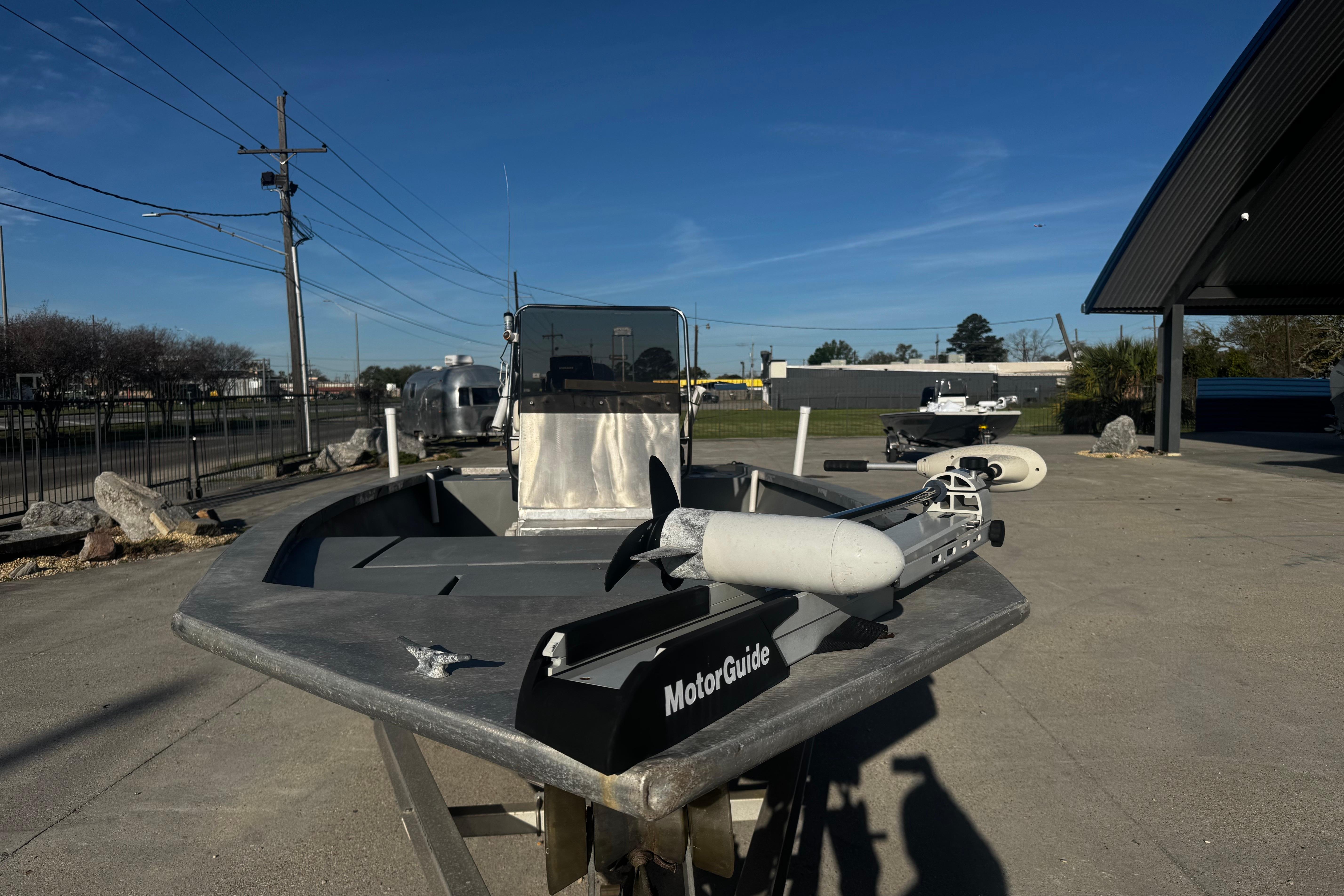 Custom Charles Leonard 21 boat, 2004 model, with MotorGuide trolling motor in a sunny outdoor setting.