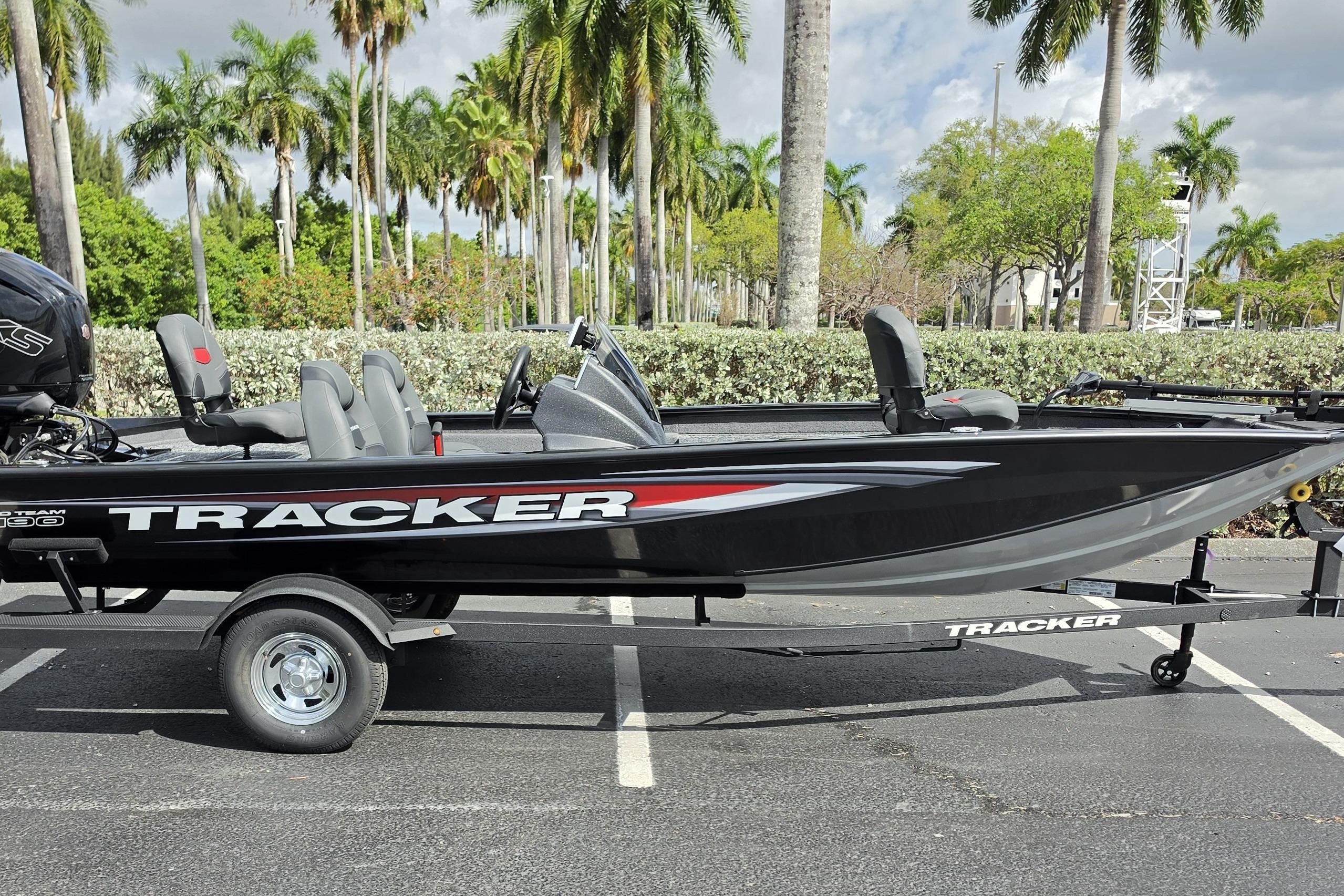 2026 Tracker Pro Team 190 boat on trailer, parked with palm trees in background.