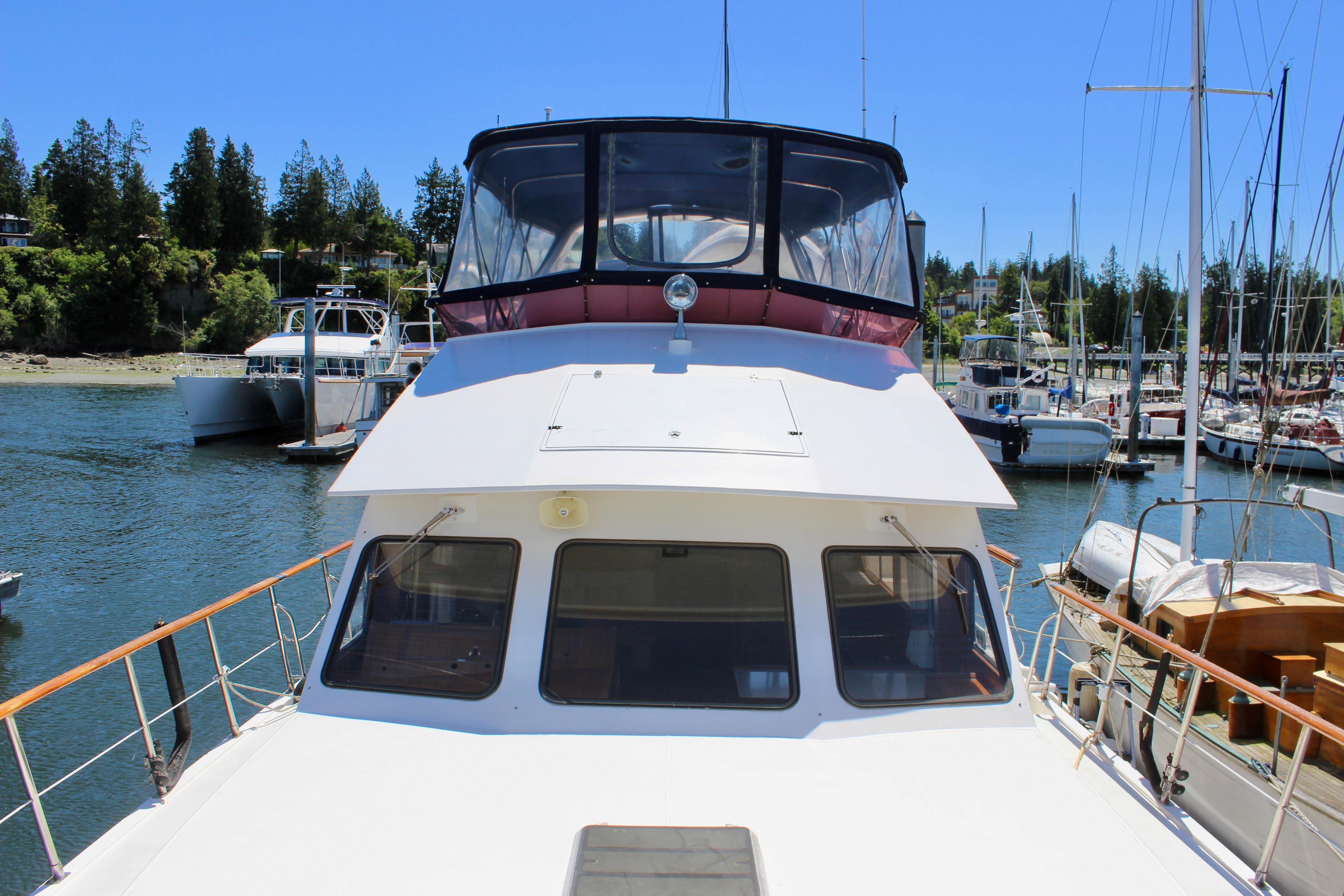 A 1986 Kha Shing Spindrift 46 is docked. It features a covered helm.