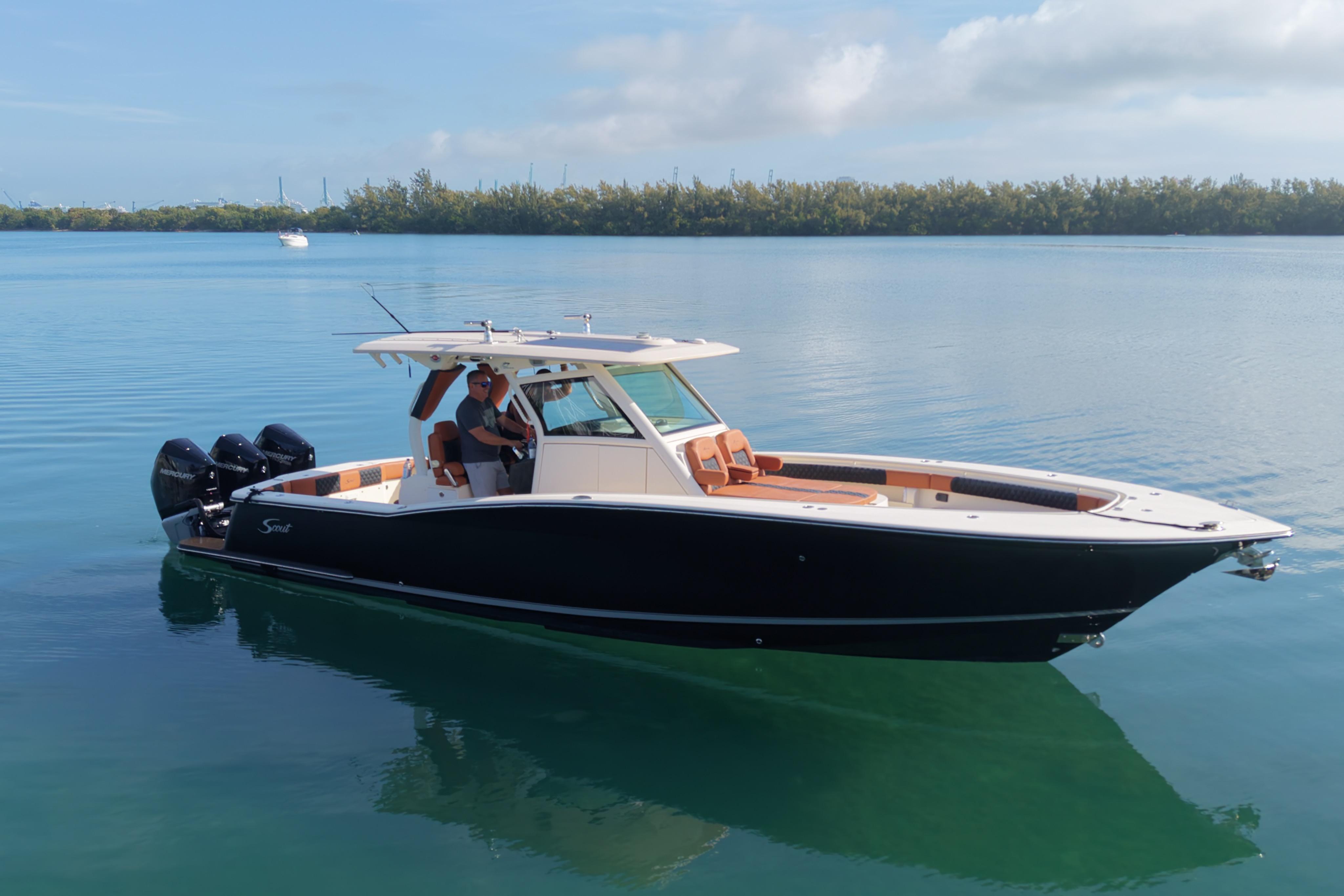 2019 Scout 355 LXF boat on calm water, featuring sleek design and triple outboard engines.