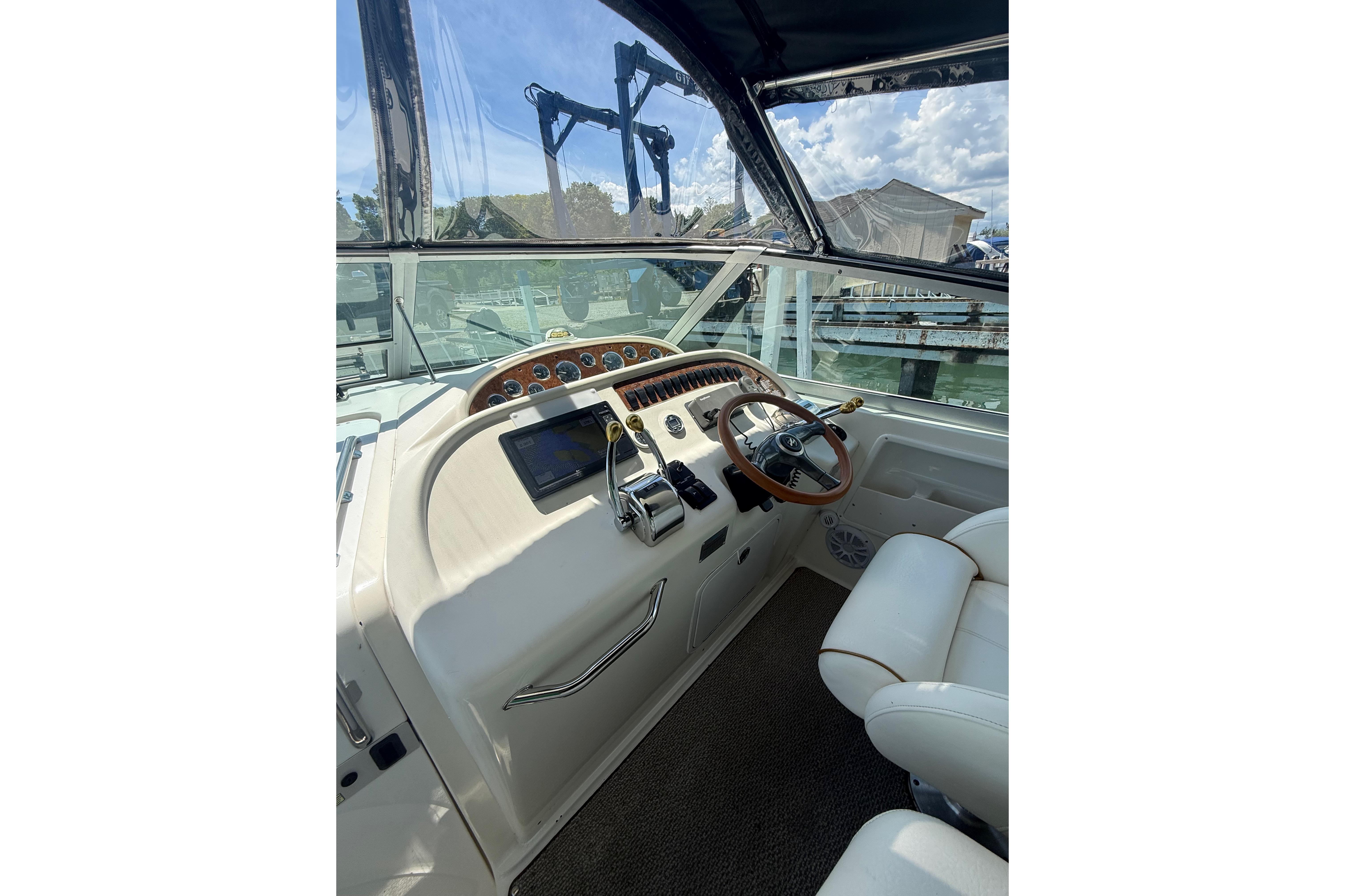 Cockpit of 1999 Sea Ray Sundancer 310 with steering wheel and navigation controls.