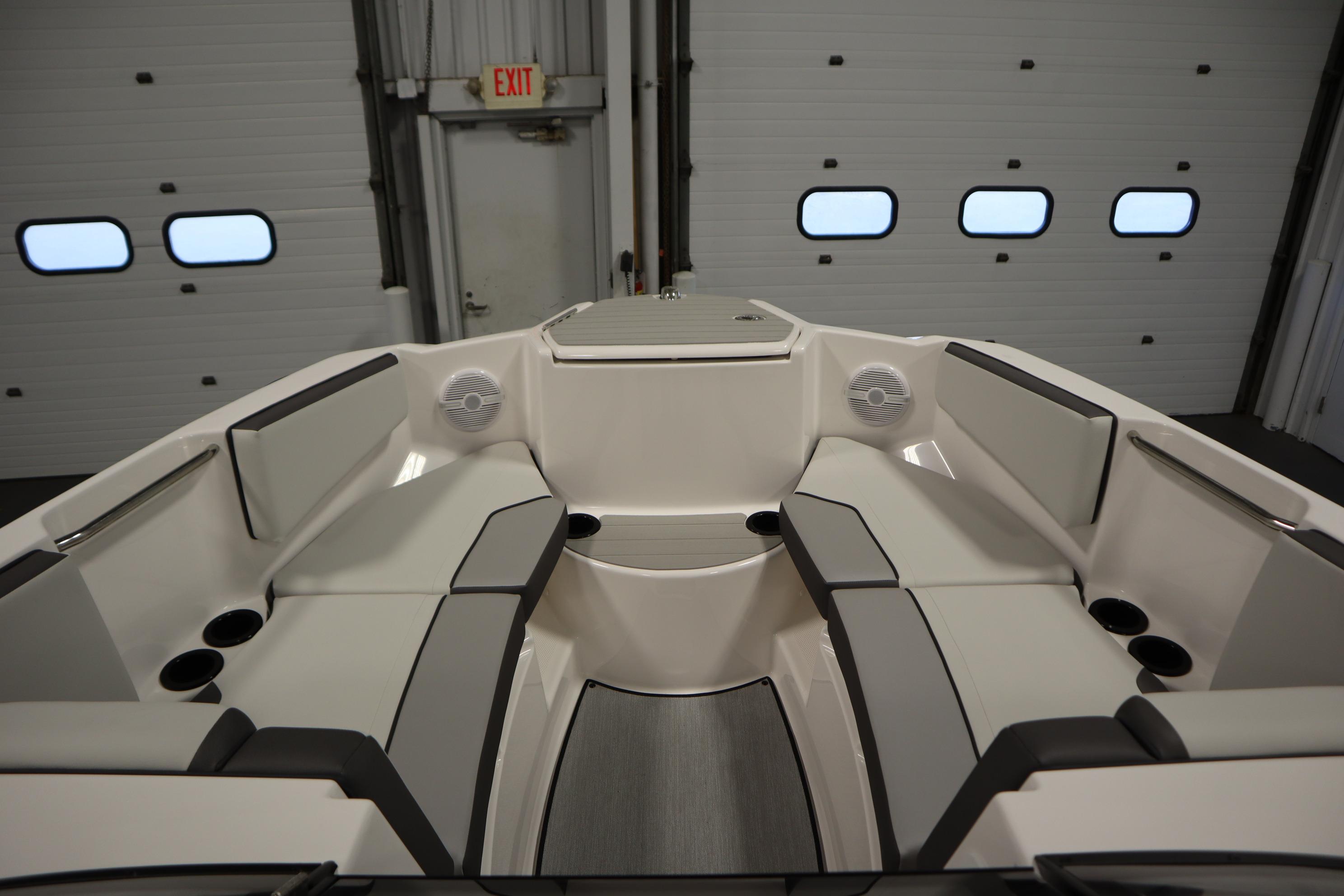 2026 Yamaha Boats AR220 interior with sleek seating and modern design in a garage setting.