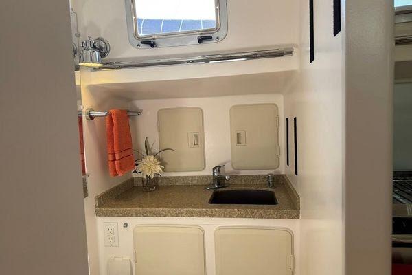 Compact bathroom sink area in a 2011 Reliance 44 yacht, featuring storage and decor.