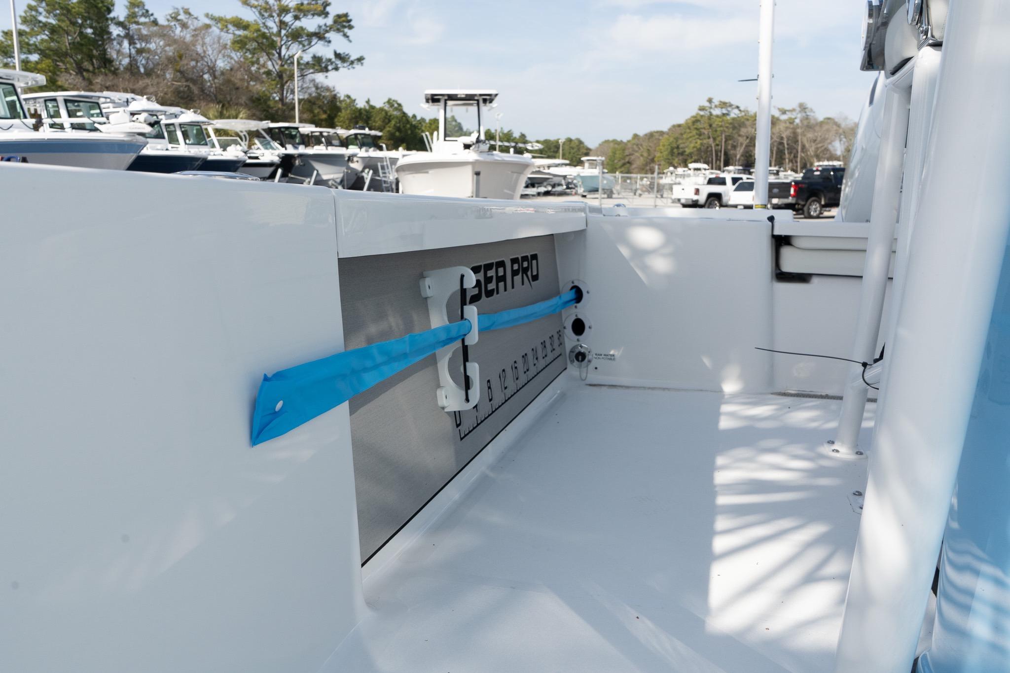 2026 Sea Pro 250 Bay boat interior with storage compartment and rod holder.