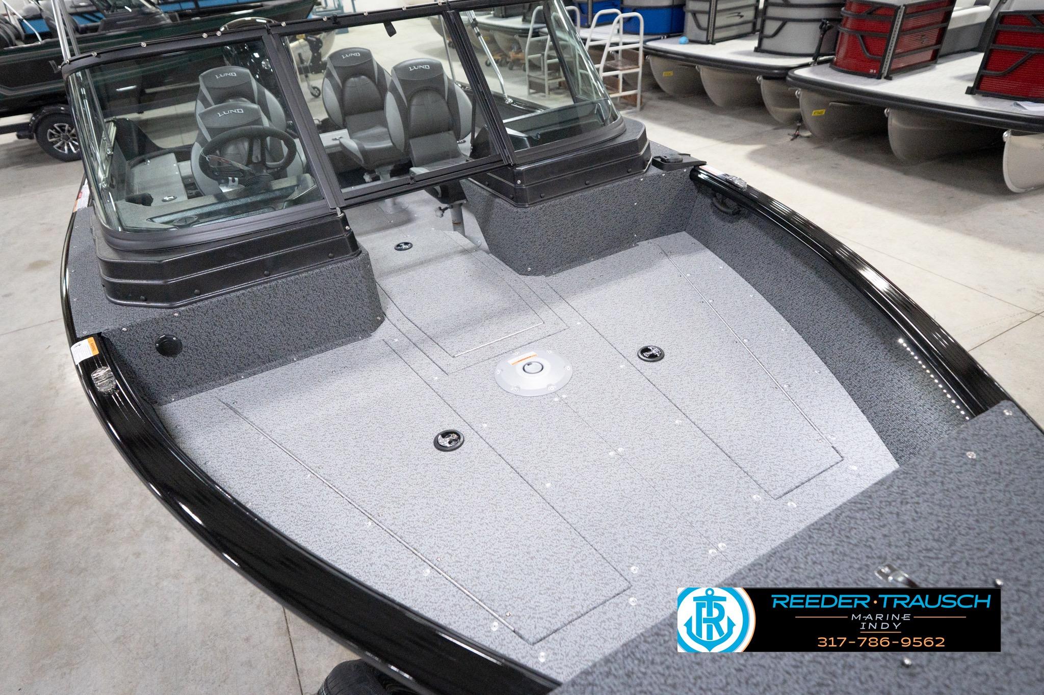 2026 Lund 1800 Explorer Sport boat interior with seating and steering wheel, displayed indoors.