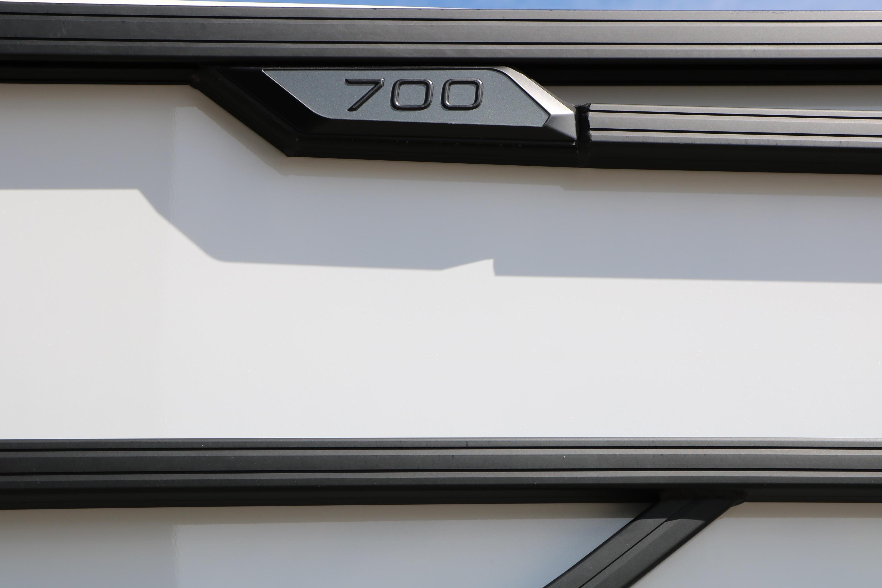 Close-up of Evotti 725 CS Tri-Toon 2026, featuring sleek black trim and "700" emblem.
