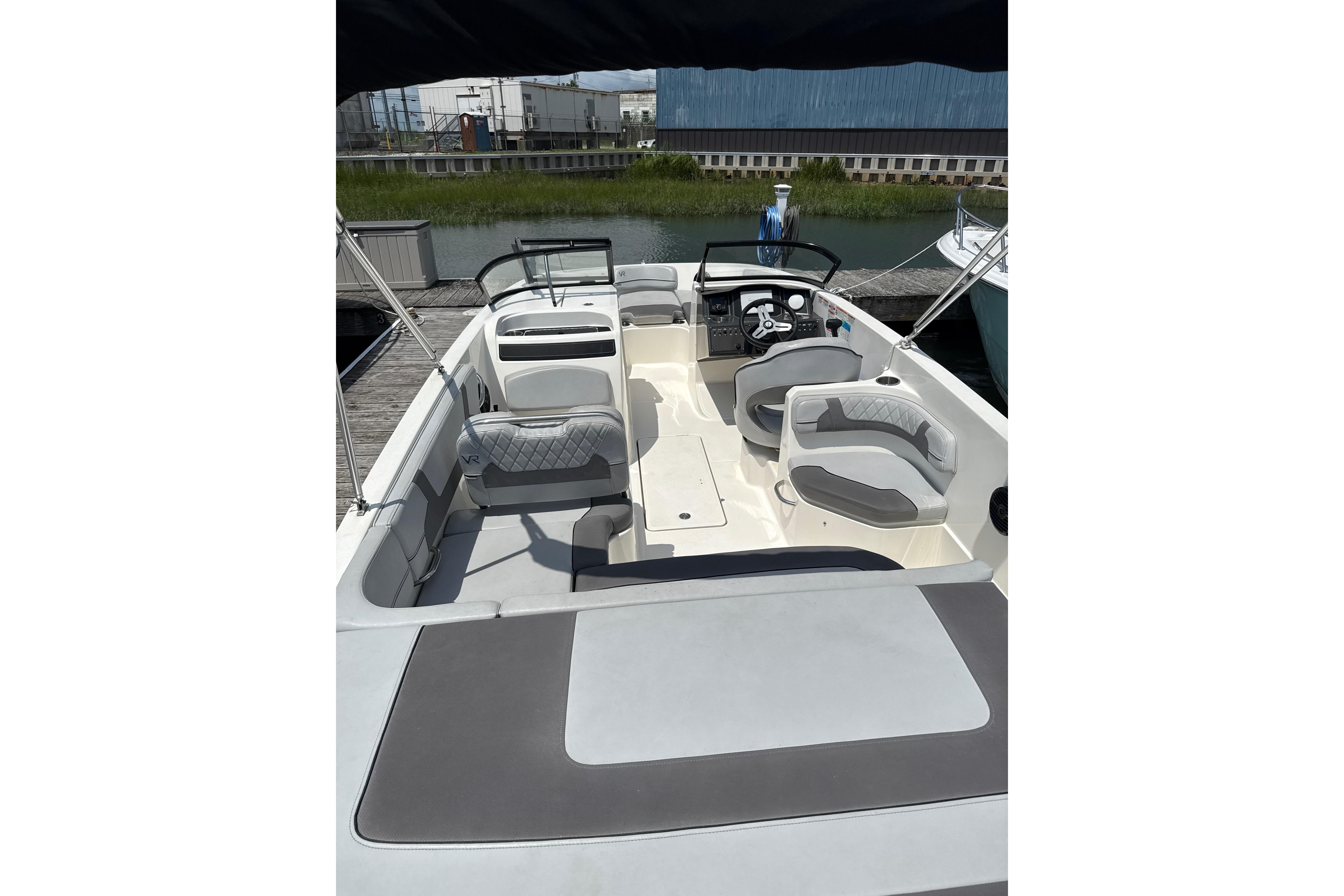 2023 Bayliner VR6 Bowrider OB with spacious seating and modern design at a dock.