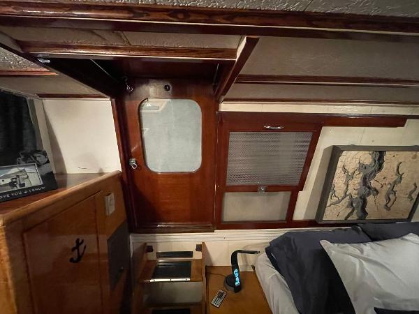 Interior of a 1951 Chris-Craft Catalina boat with wooden paneling and nautical decor.