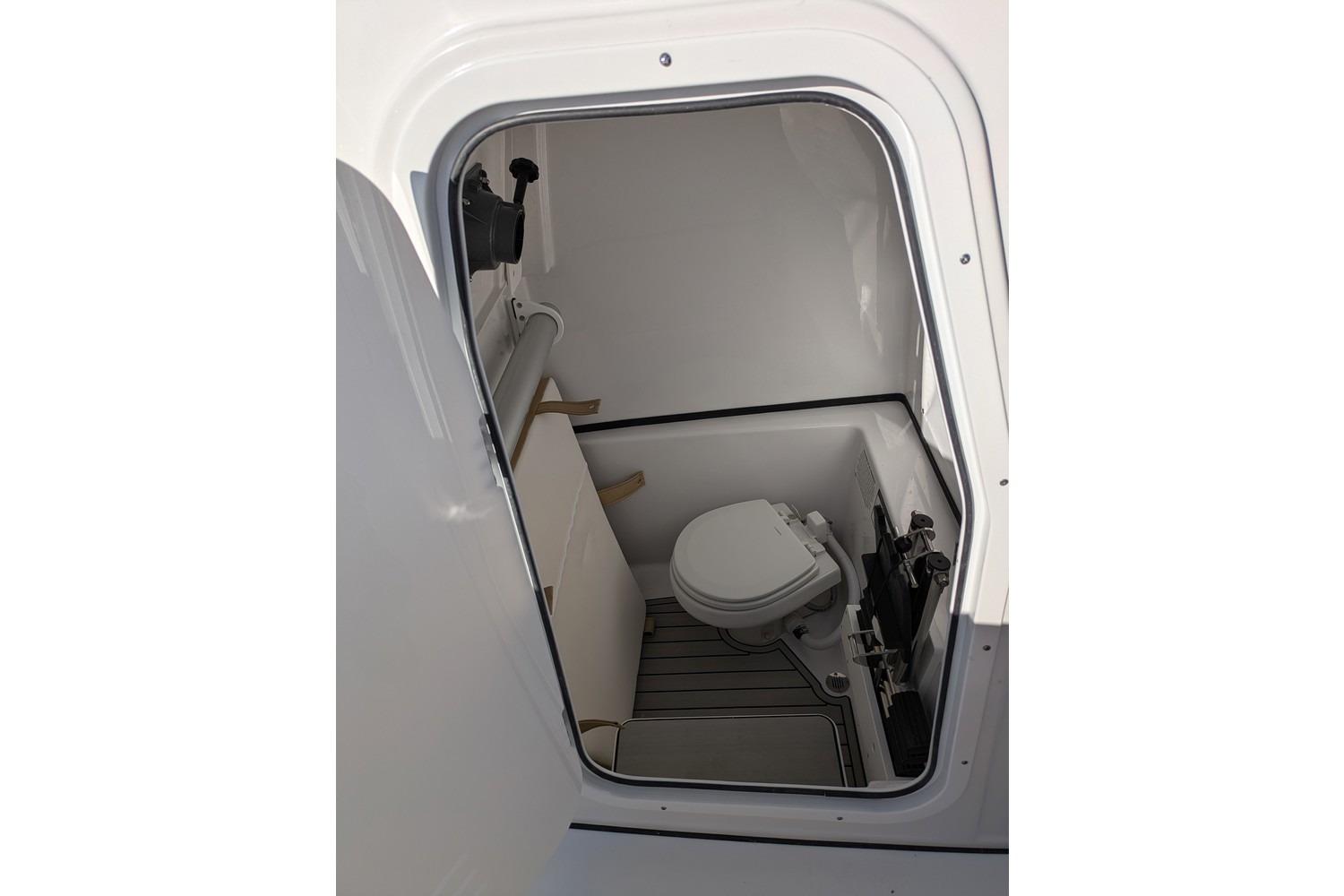 2025 Sportsman Open 282 Center Console boat interior with compact marine toilet.