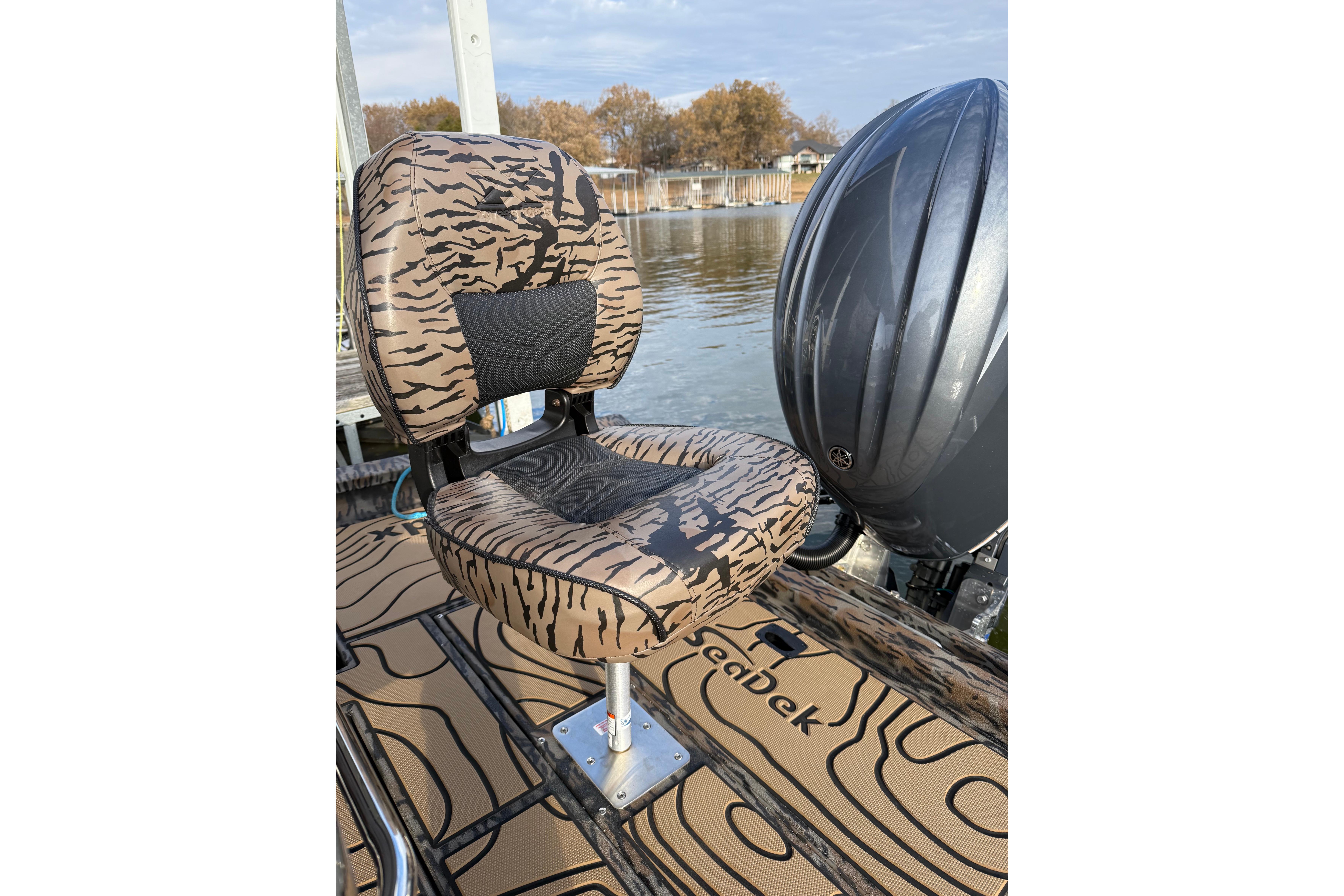 Tiger-striped boat seat on 2025 Xpress H22B Bay, near water.