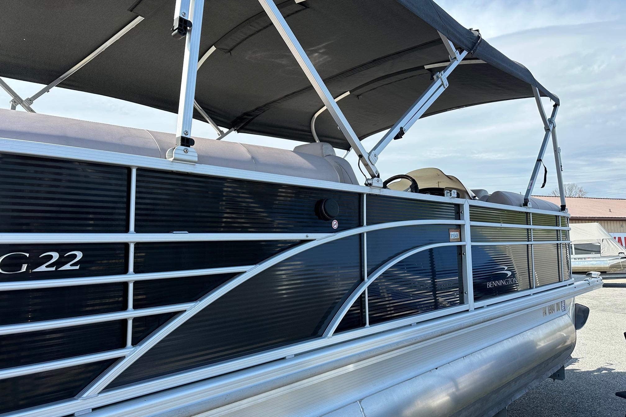 2017 Bennington 22 GPD pontoon boat with canopy, side view.