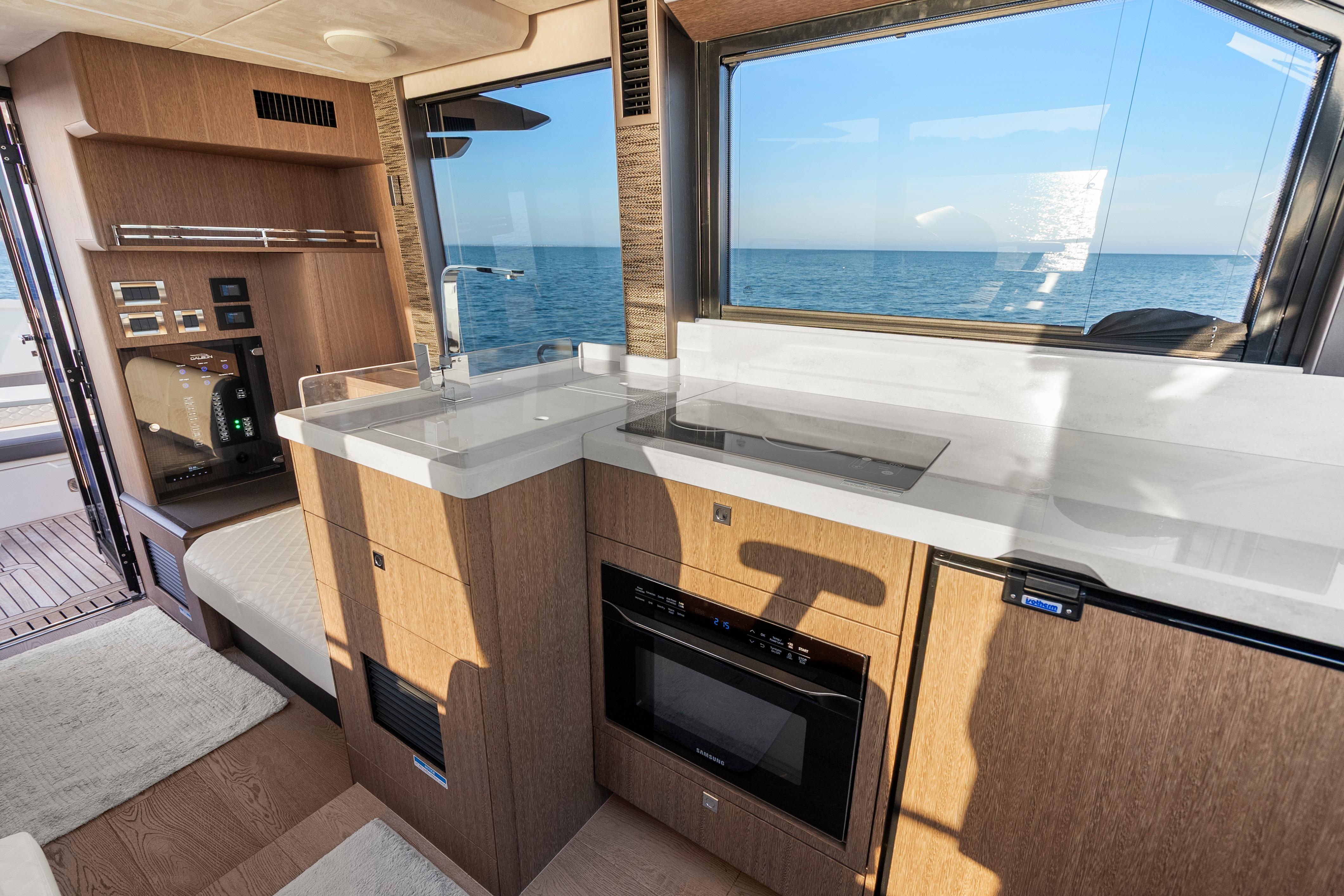 Modern kitchen interior of 2023 Galeon 400 Fly yacht with ocean view.