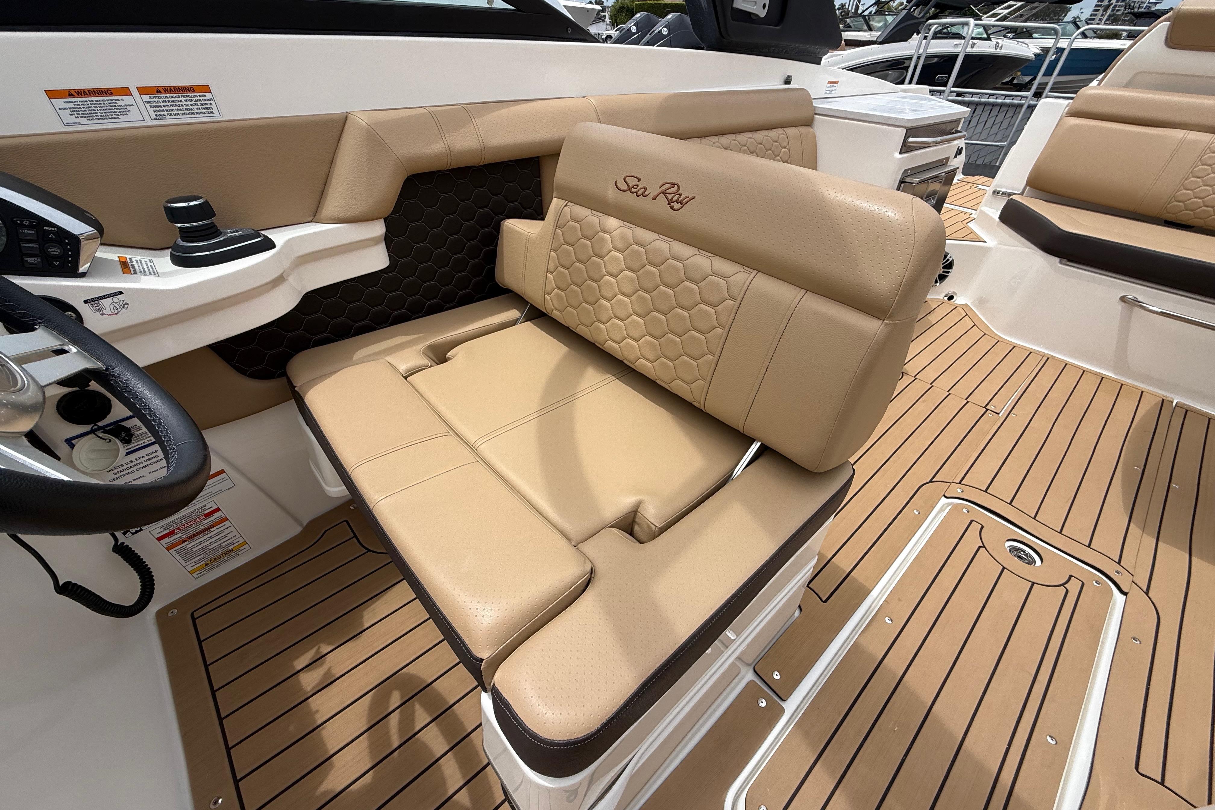 2022 Sea Ray SDX 290 Outboard interior with tan seating and wood-style flooring.