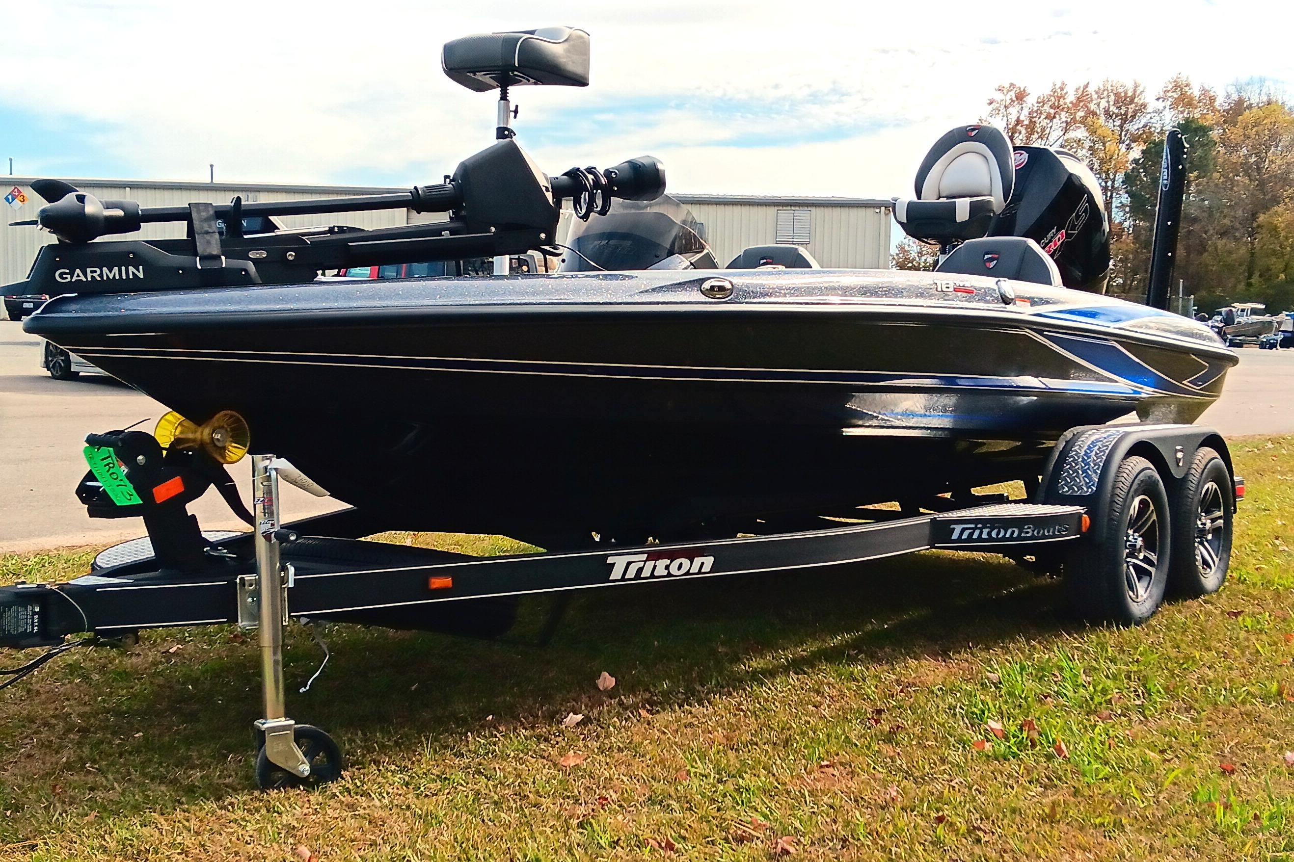 2026 Triton 18 TrX boat on trailer, featuring Garmin equipment, parked on grass.