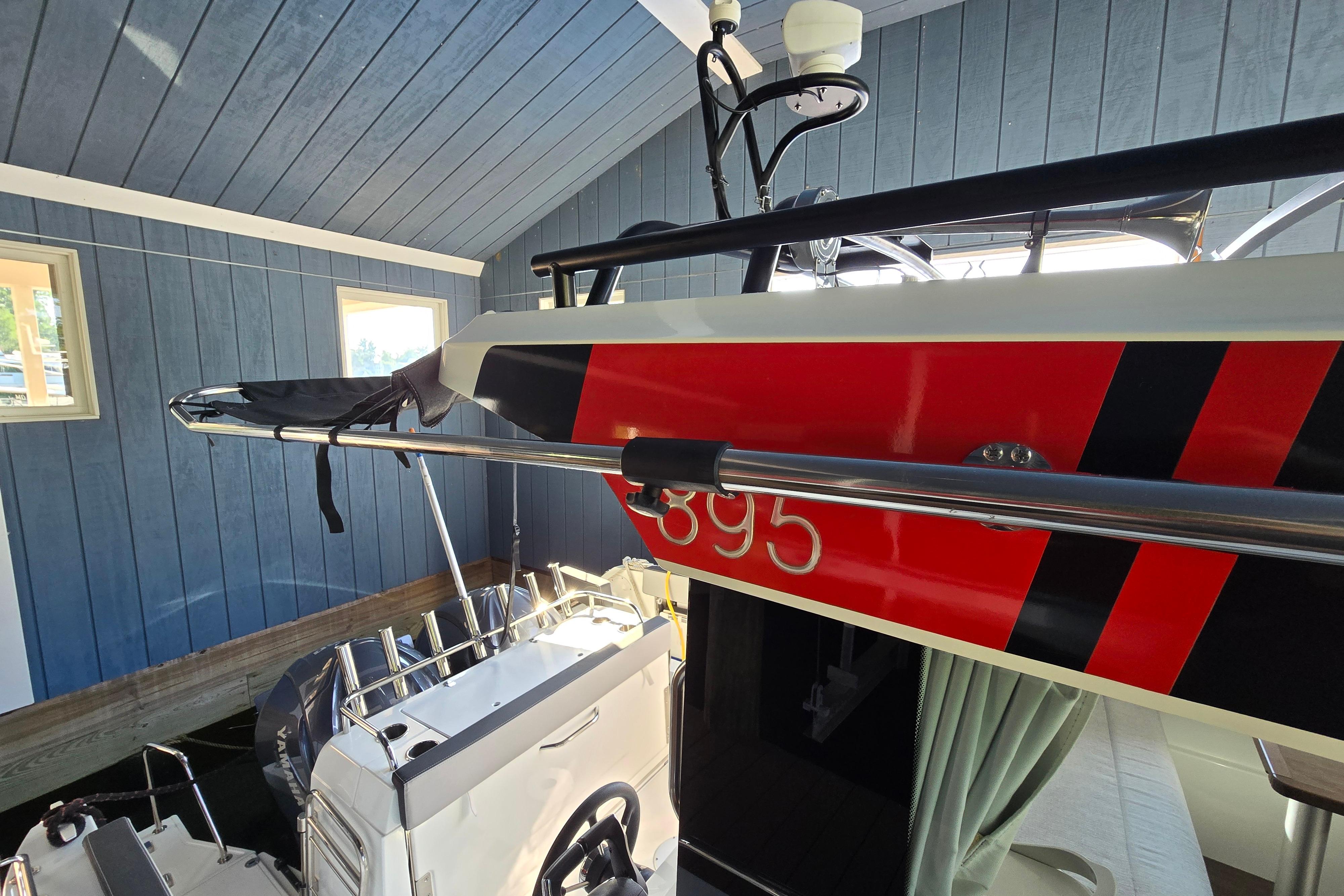 The boat is a 2023 Jeanneau NC Sport 895, docked in a covered area.