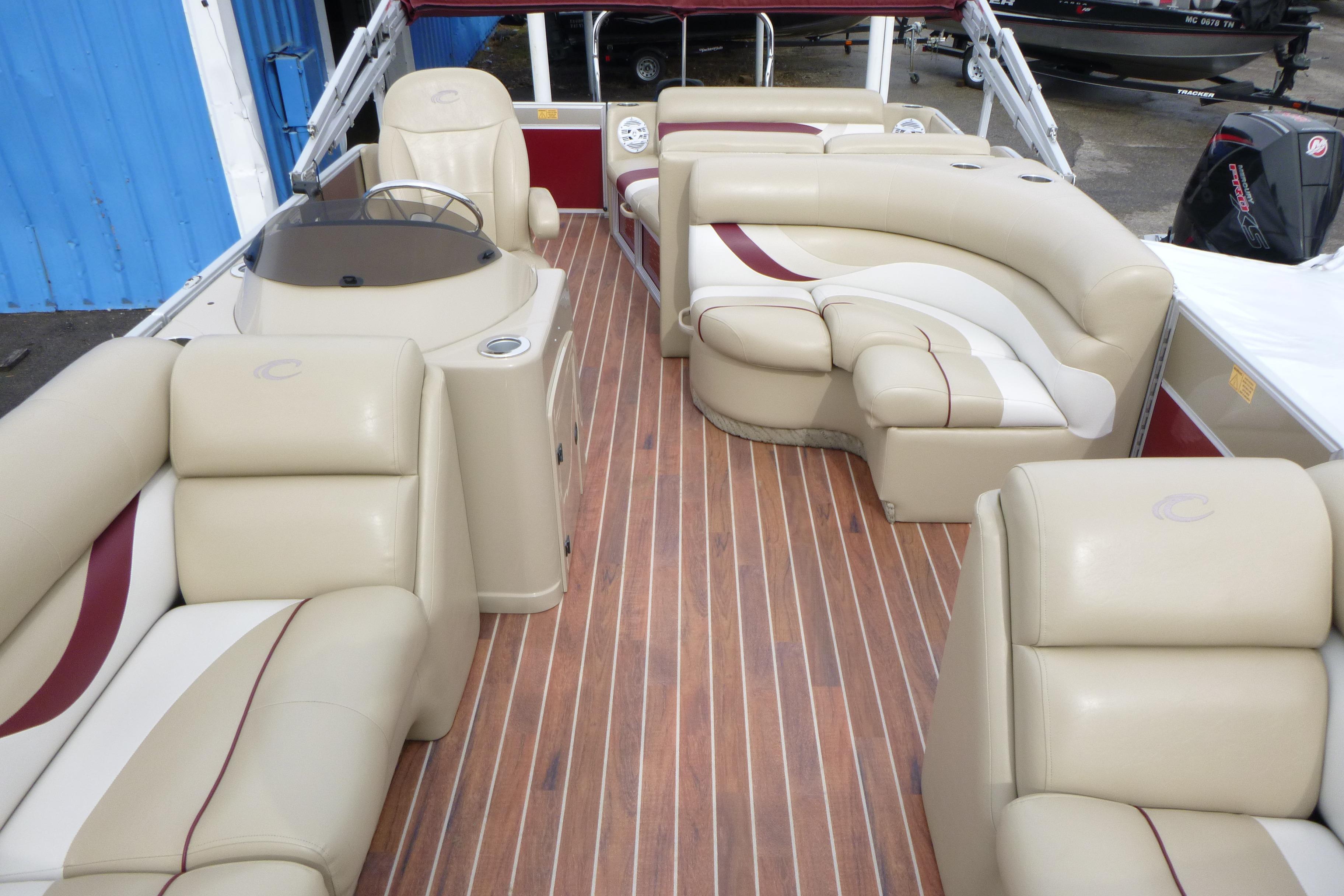 Luxurious interior of a 2012 Crest 230SLR Classic boat with plush seating and wood flooring.