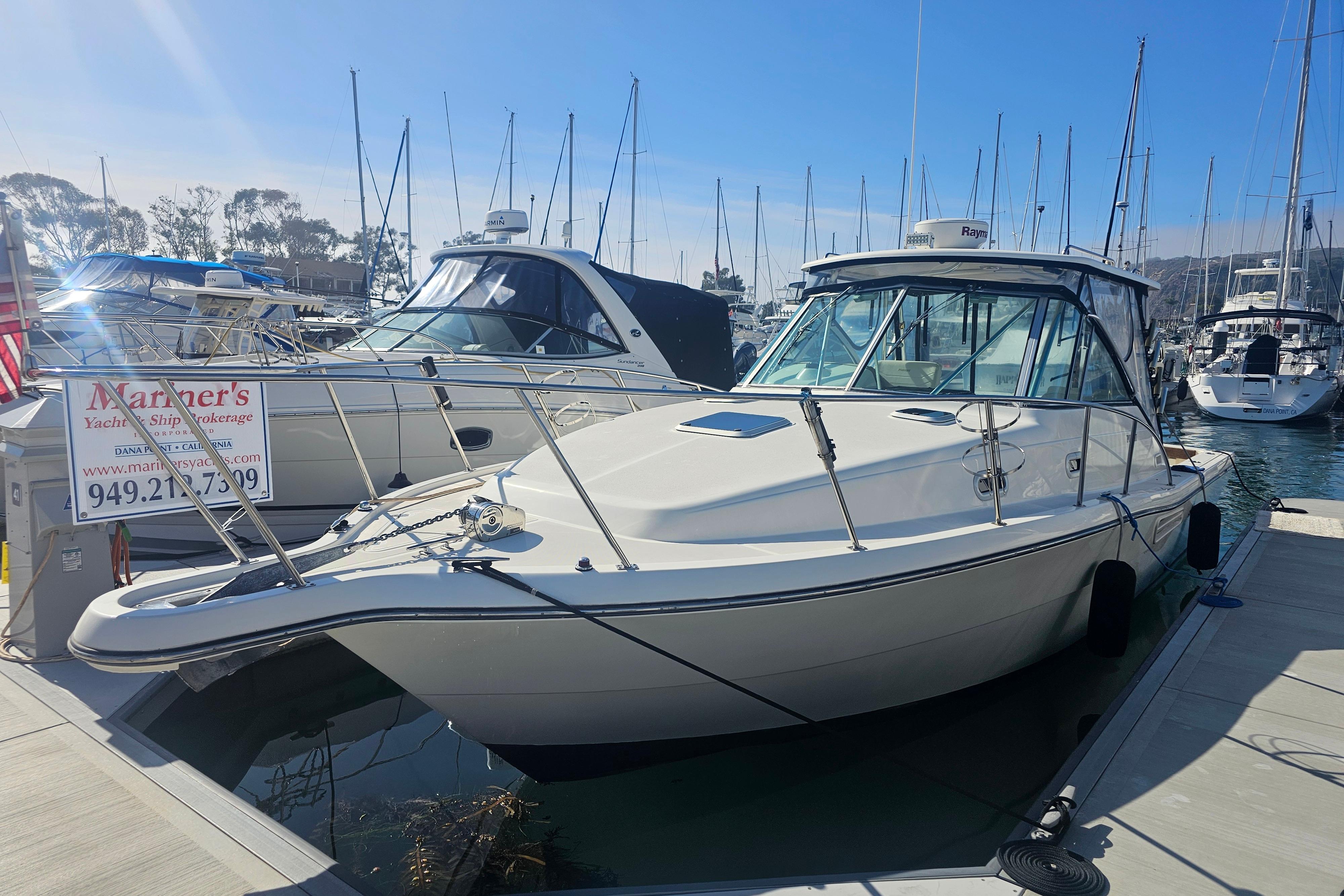2001 Pursuit 3000 Express boat docked at marina, clear sky, surrounded by other vessels.
