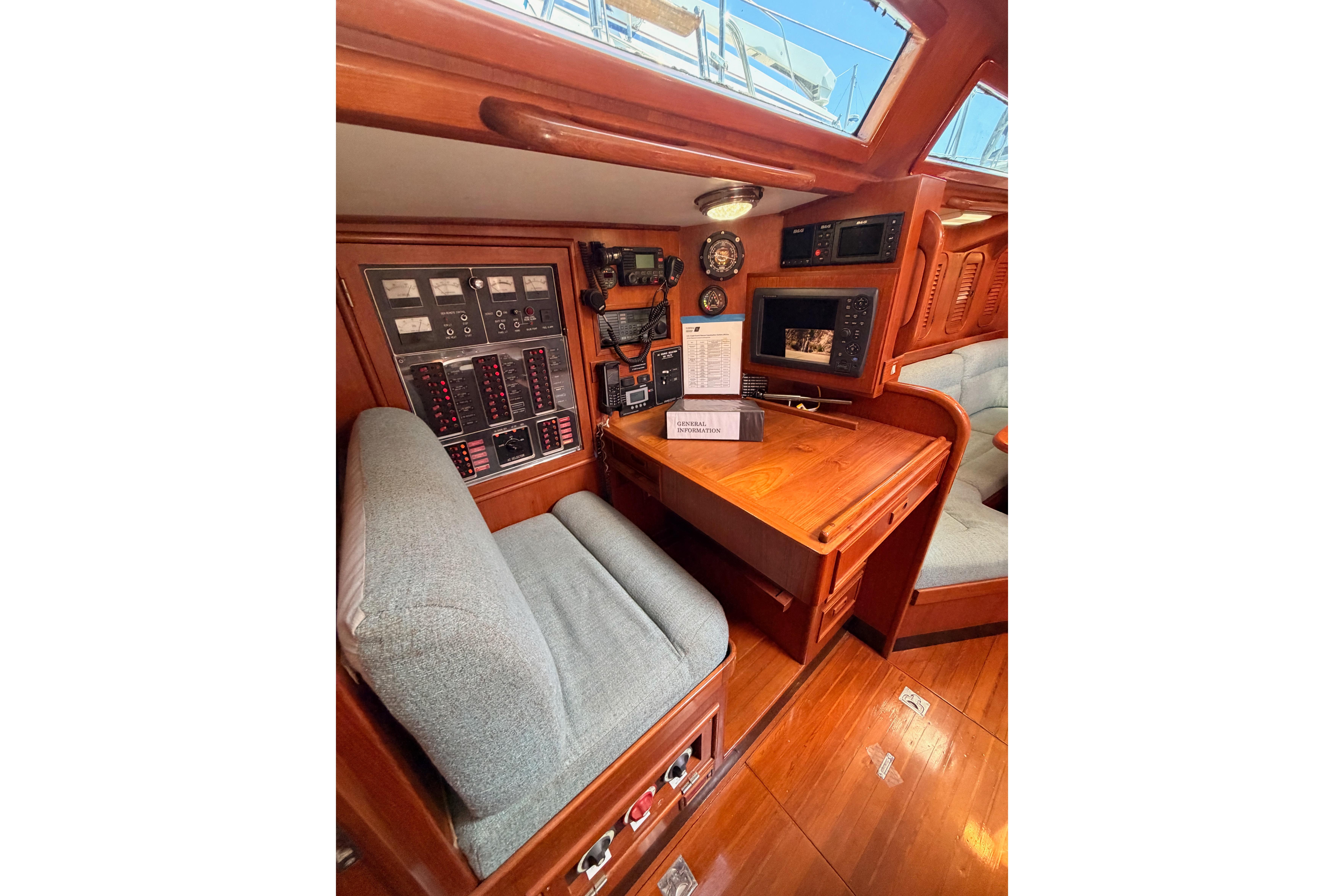 Navigation station of a 1991 Hylas 51 yacht with control panels and seating.