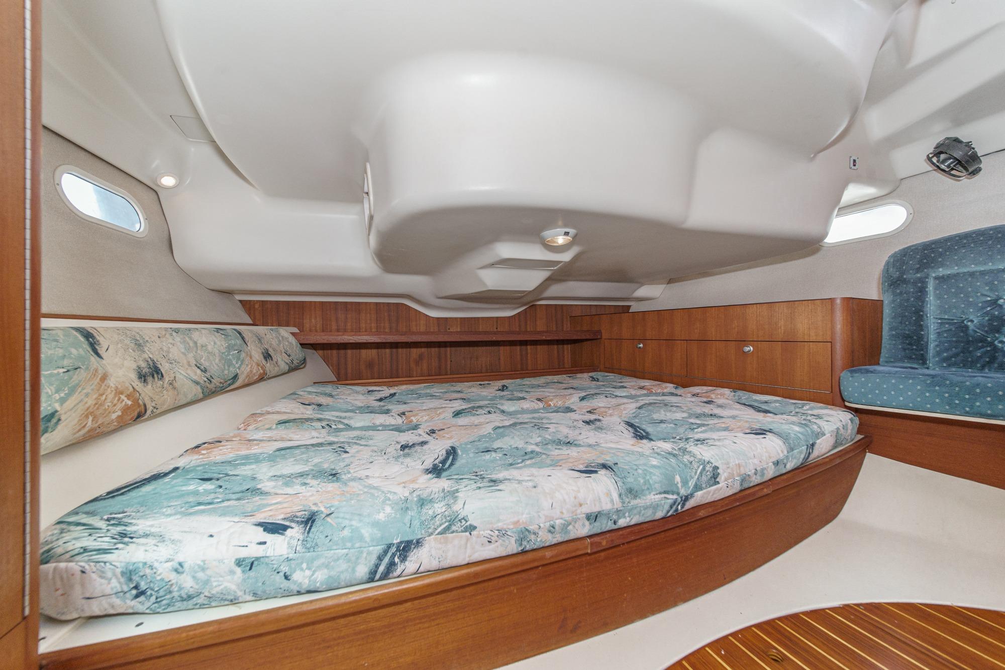 Interior cabin of a 1996 Hunter 376 sailboat with a cozy bed and wooden accents.