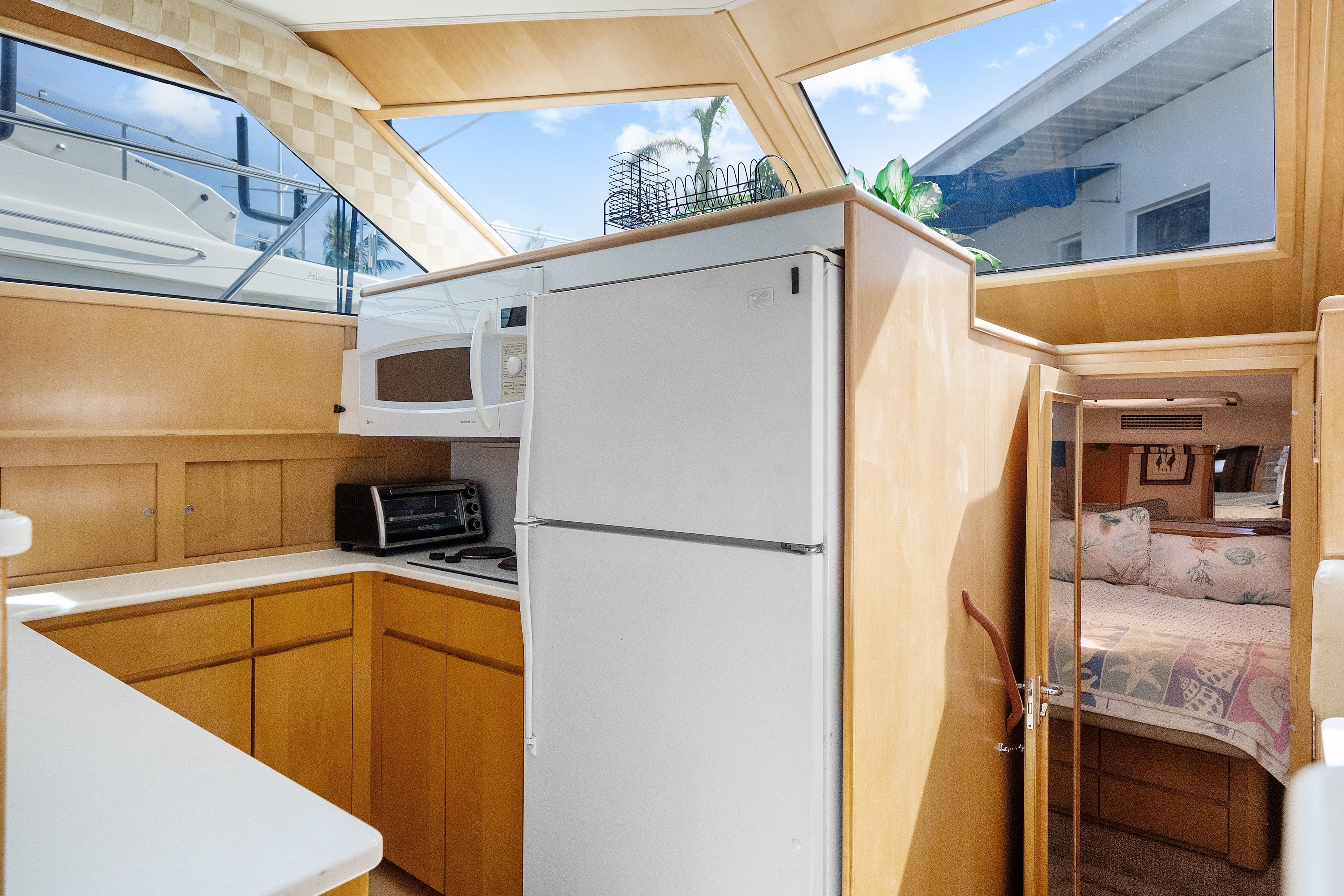 Interior of 1999 Hatteras 52 Cockpit Motor Yacht with kitchen and cozy bedroom.