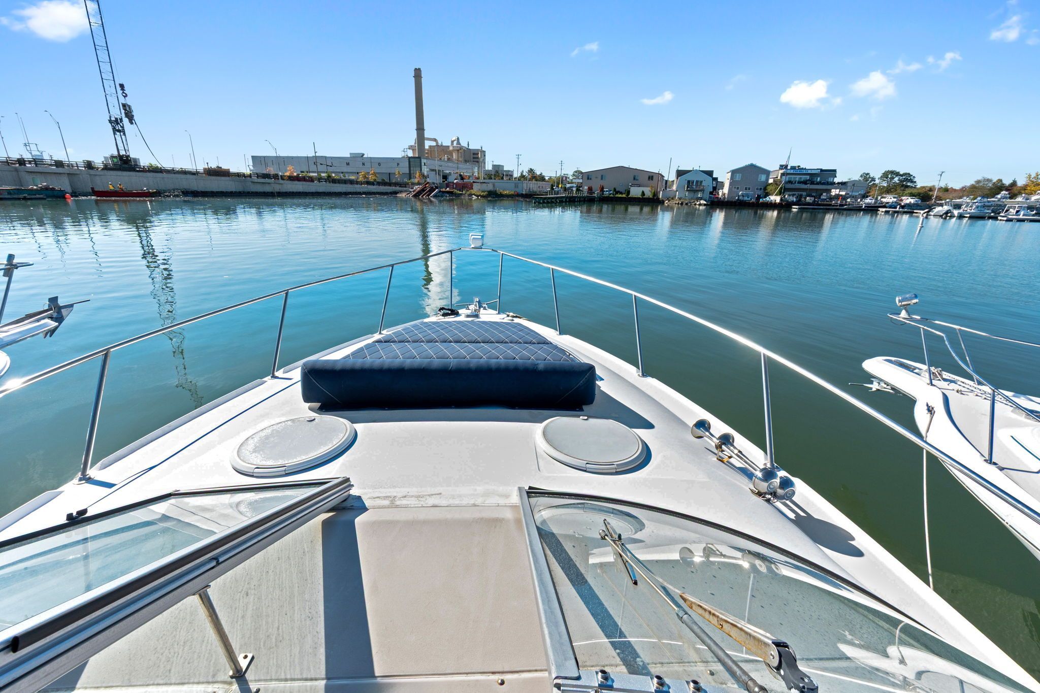 The 2007 Larson Cabrio 330 is docked in a harbor, surrounded by calm water and buildings.