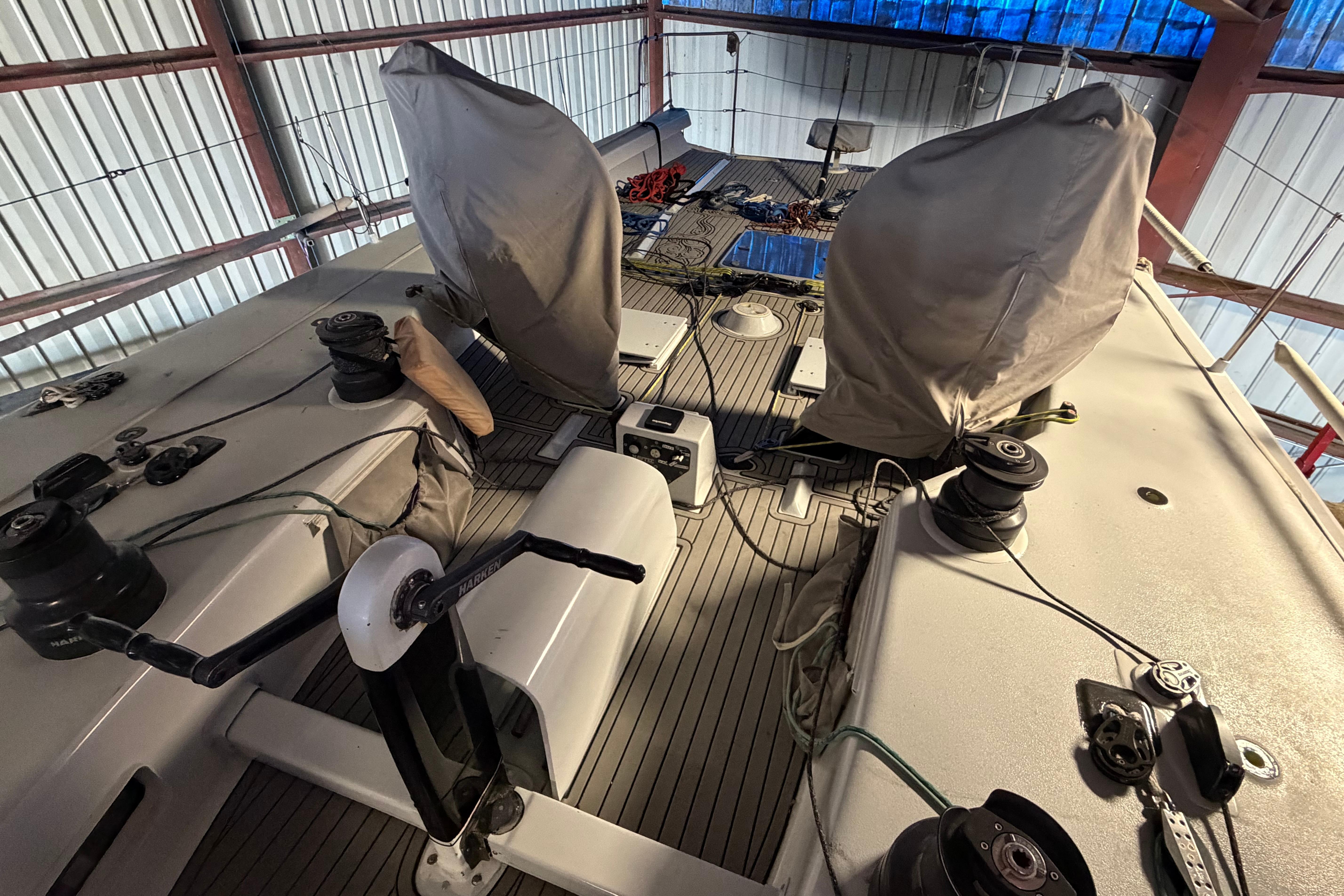 Deck of Andrews 63 sailboat in storage, featuring winches and covered equipment.