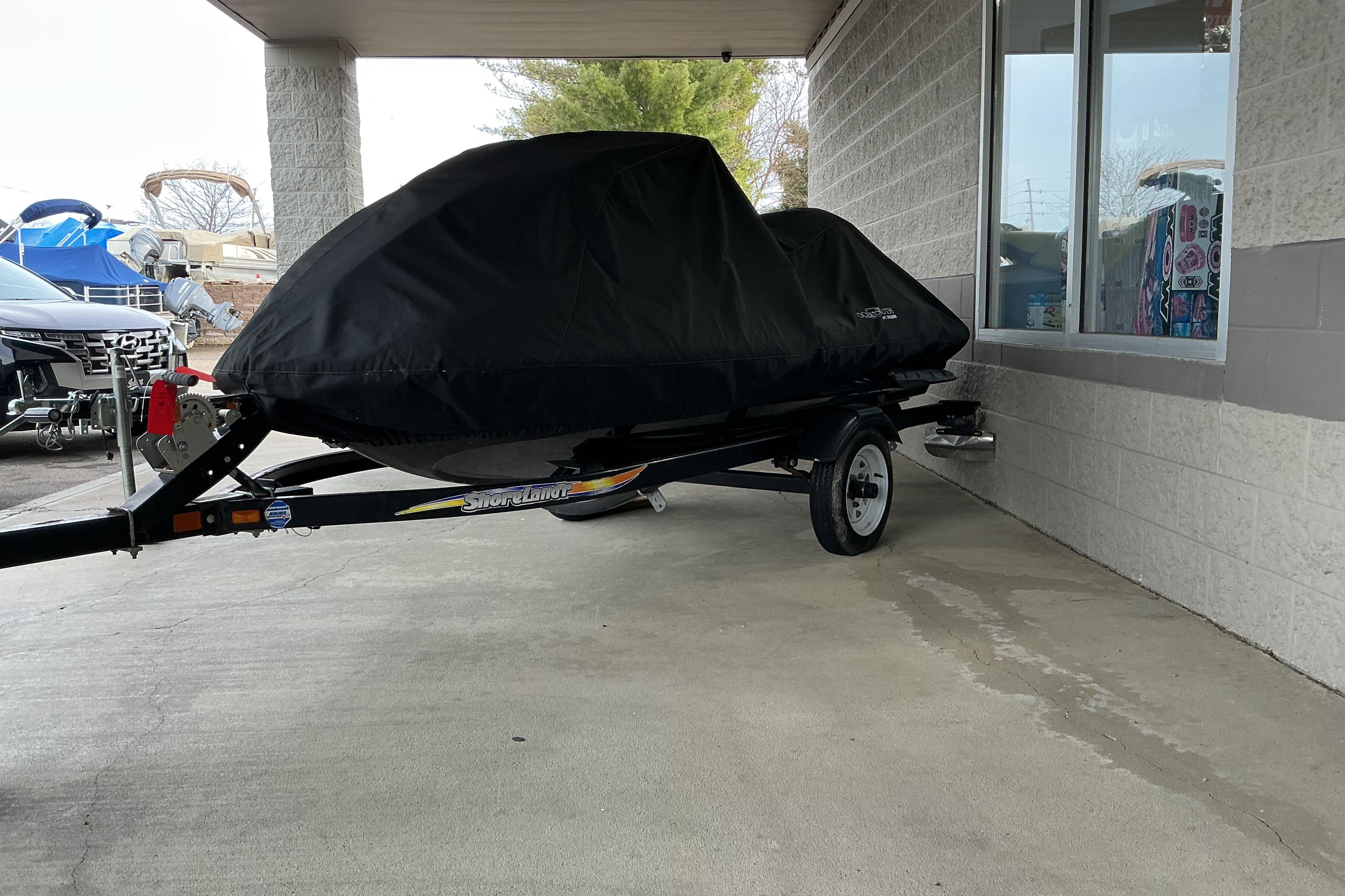 2008 Yamaha WaveRunner FX Cruiser SHO covered on a trailer, parked near a building.