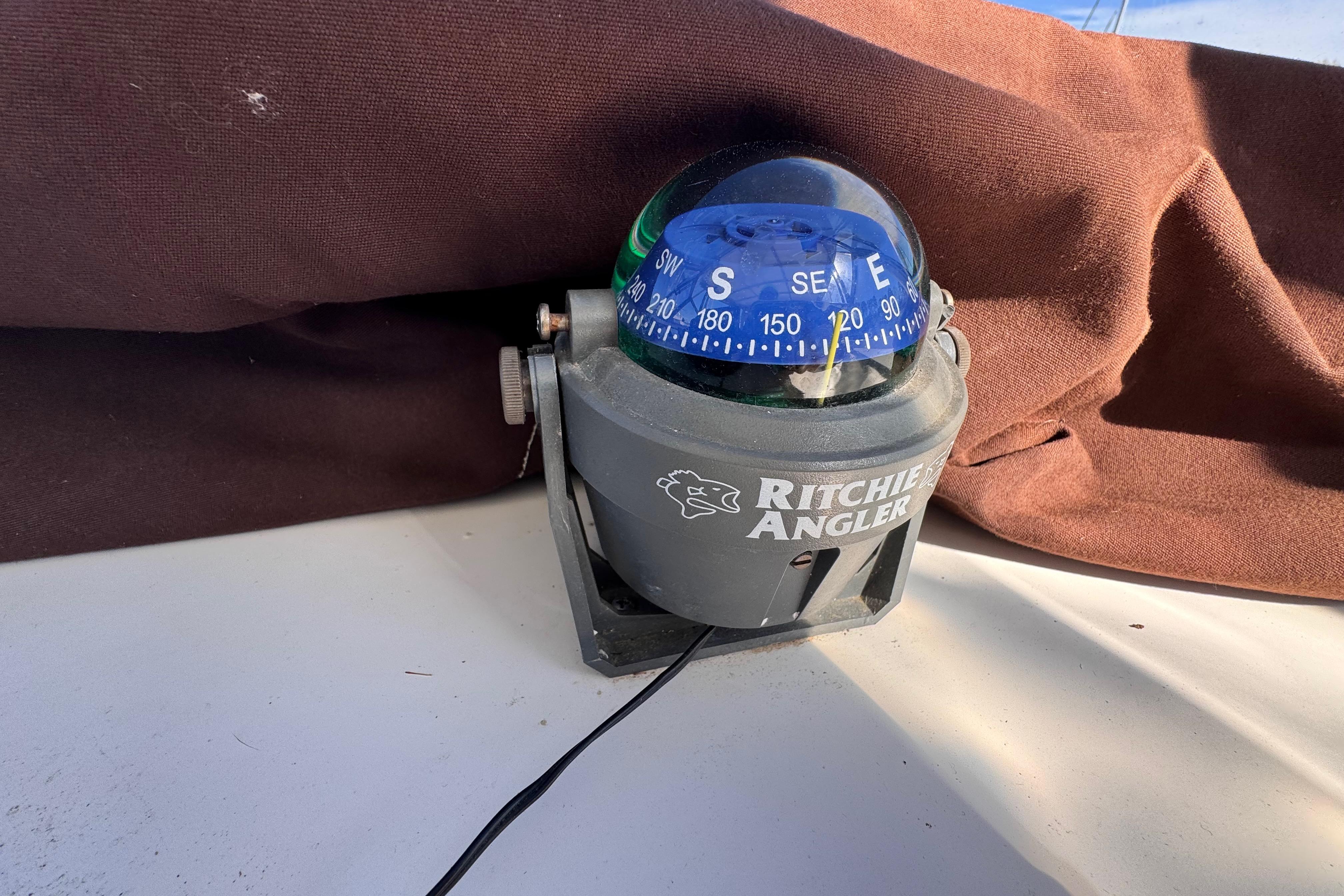 Ritchie Angler compass on 1987 Luhrs Alura 30 boat, with brown fabric backdrop.