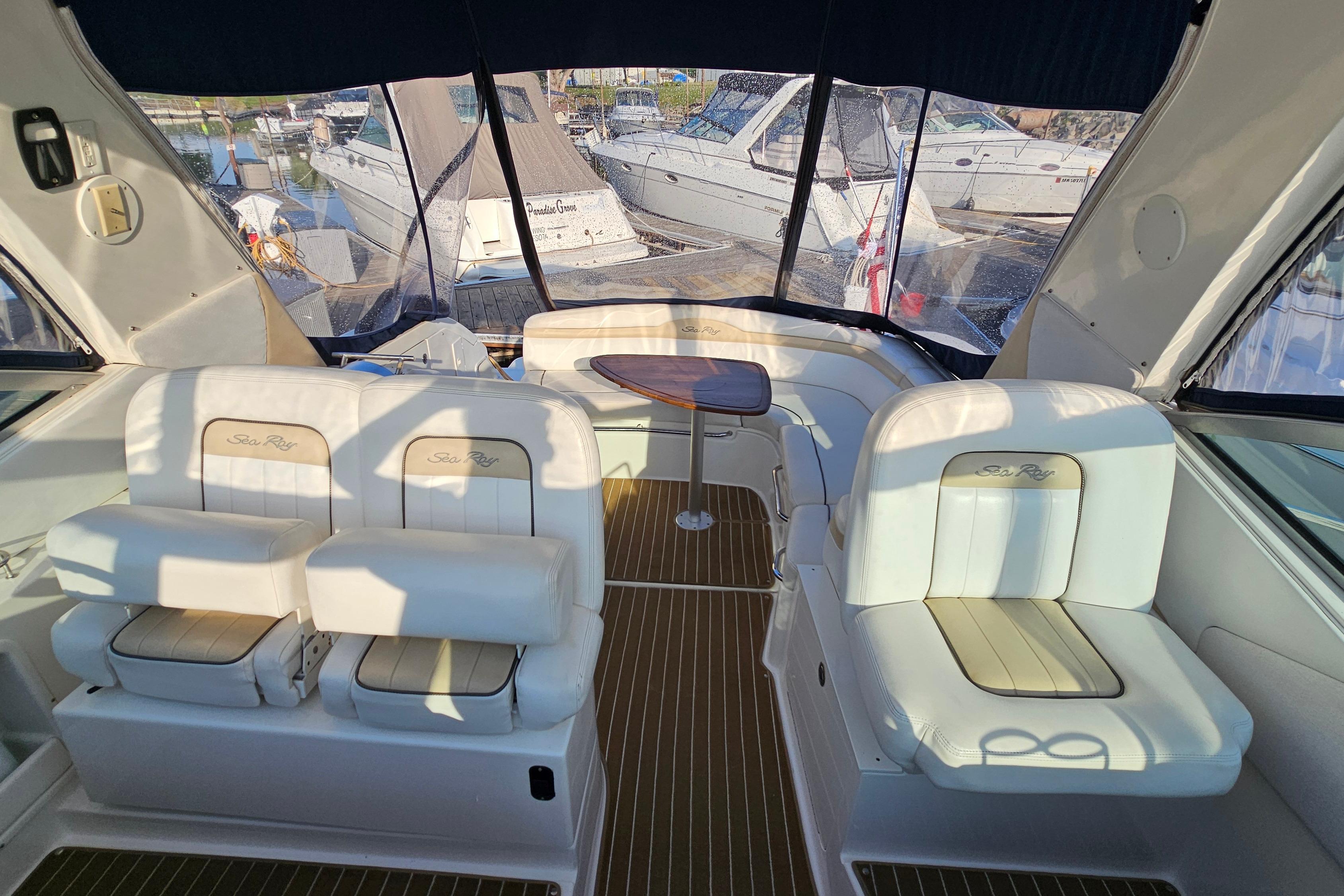 Interior of 2008 Sea Ray Sundancer 350 yacht with white seating and wooden table.