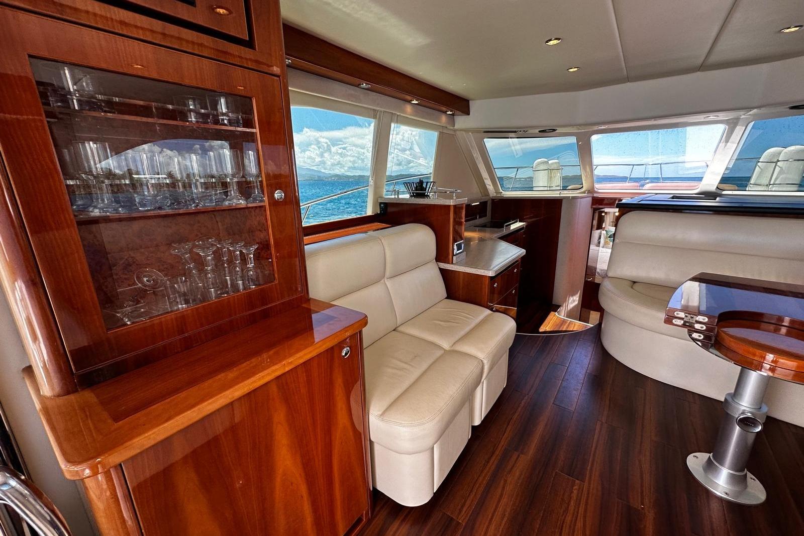 Luxurious interior of 2012 Riviera 43 Flybridge yacht with elegant wood finishes and plush seating.