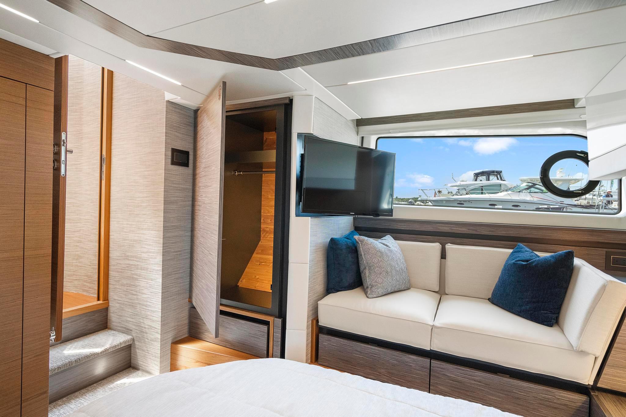 Luxurious interior of 2022 Tiara Yachts C49 Coupe with sofa, TV, and window view.