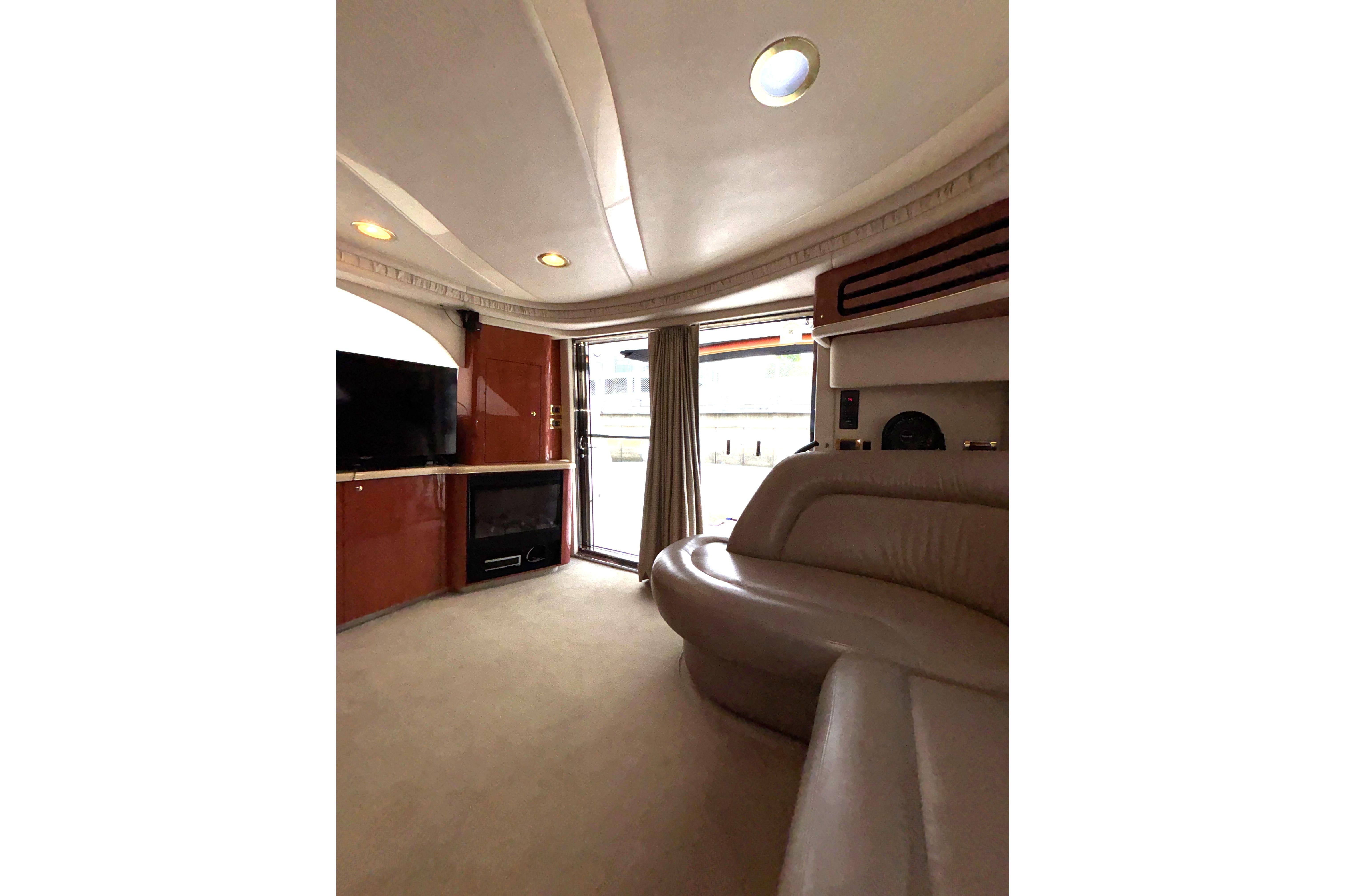 Luxurious interior of 1999 Sea Ray 480 Sedan Bridge yacht with plush seating and entertainment system.